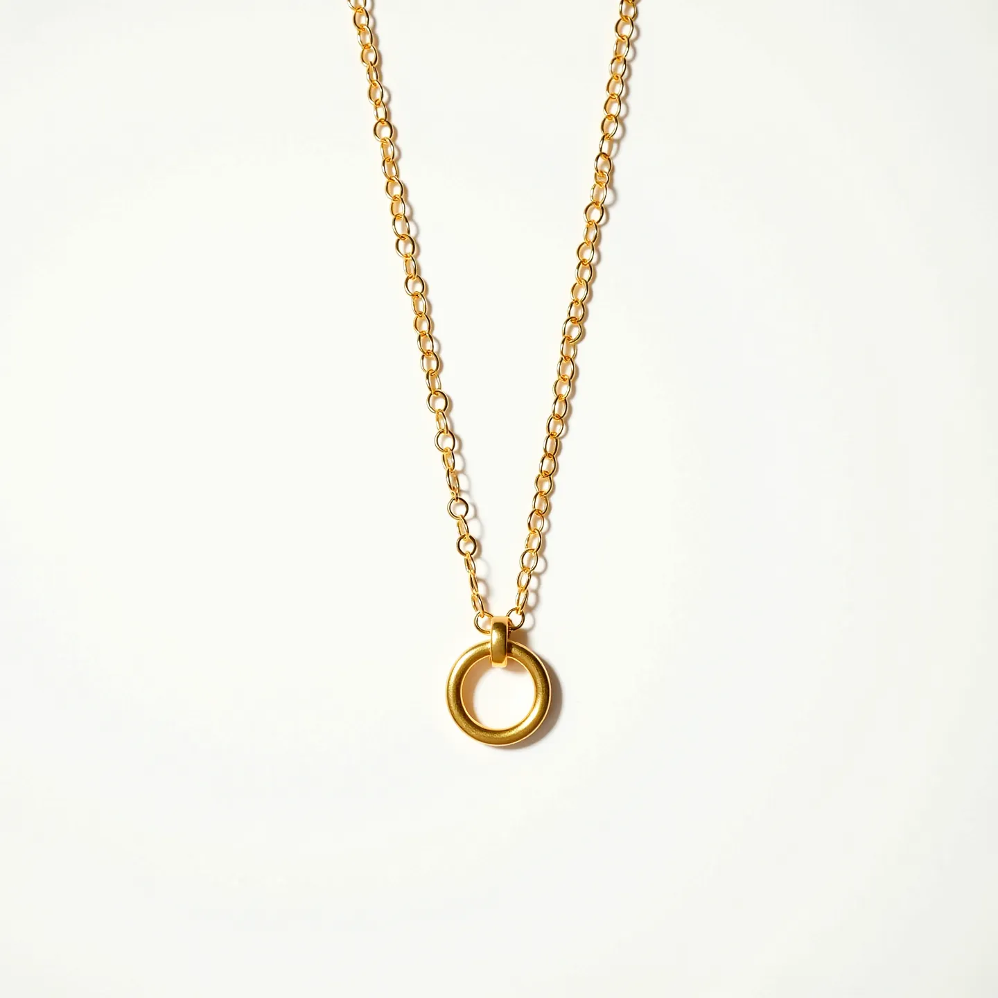 This gold circle necklace features a delicate chain crafted from gold links, providing a classic and elegant appearance. At its center is a simple yet refined circular pendant, also made of gold, which serves as the focal point of the piece. The necklace likely includes a standard clasp attachment, typically a lobster clasp, to ensure secure and adjustable fastening. The overall design emphasizes minimalism and sophistication, making it a versatile accessory suitable for various occasions.