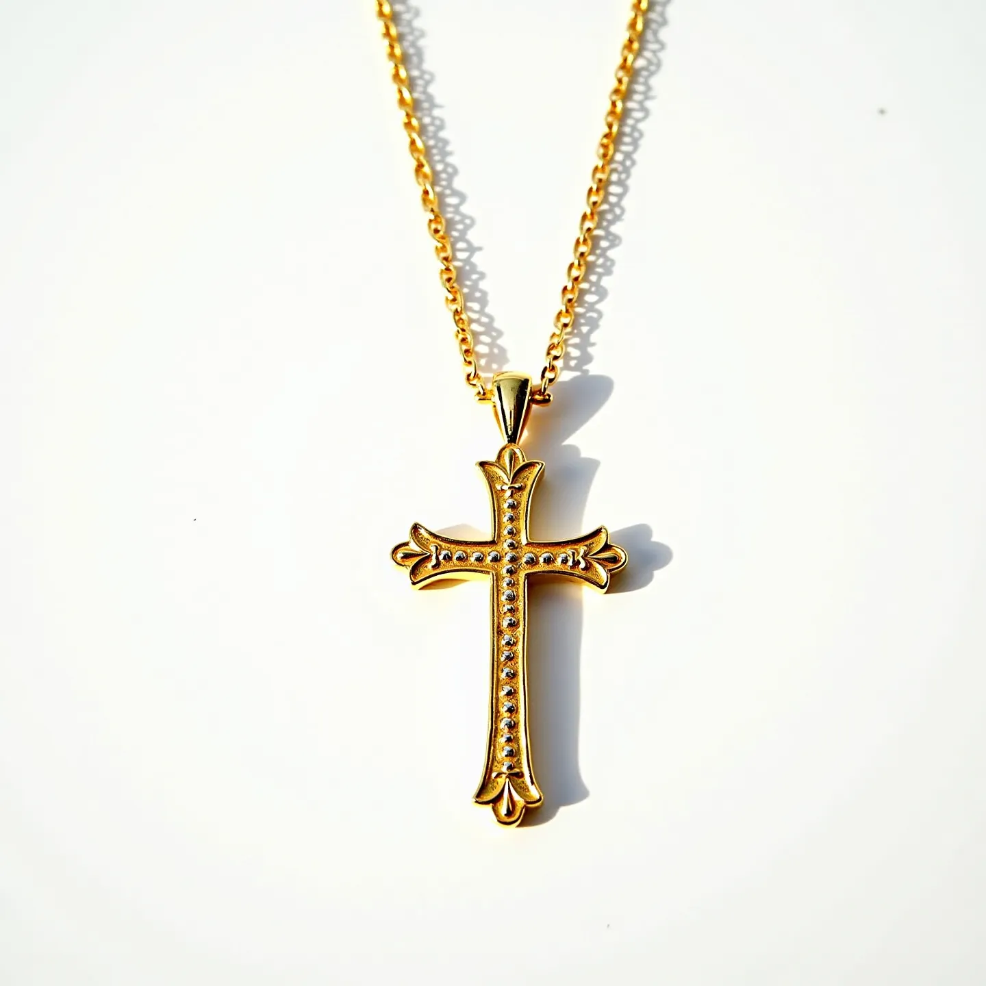 This gold cross necklace features a beautifully crafted cross pendant adorned with a series of small, sparkling gemstones that are likely diamonds or cubic zirconia, set in a pavé arrangement along the center and arms of the cross. The cross has elegant, ornamental edges, enhancing its classic design. The chain appears to be made of polished gold links that complement the pendant's finish. The necklace is secured with a traditional lobster clasp, ensuring both style and functionality in its design.