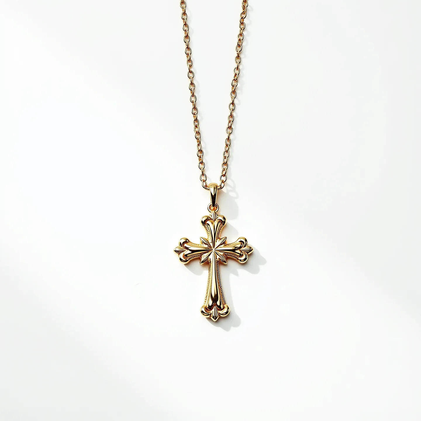 This gold cross necklace features a beautifully designed cross pendant made of gold. The elegant cross has ornate, fleur-de-lis details at each end, contributing to its intricate and classic appearance. The necklace chain is composed of slender gold links, adding a simple yet refined touch. The pendant is securely attached to the chain via a small gold bail, allowing it to hang gracefully. This piece combines timeless design with elegant materials for an overall exquisite look.