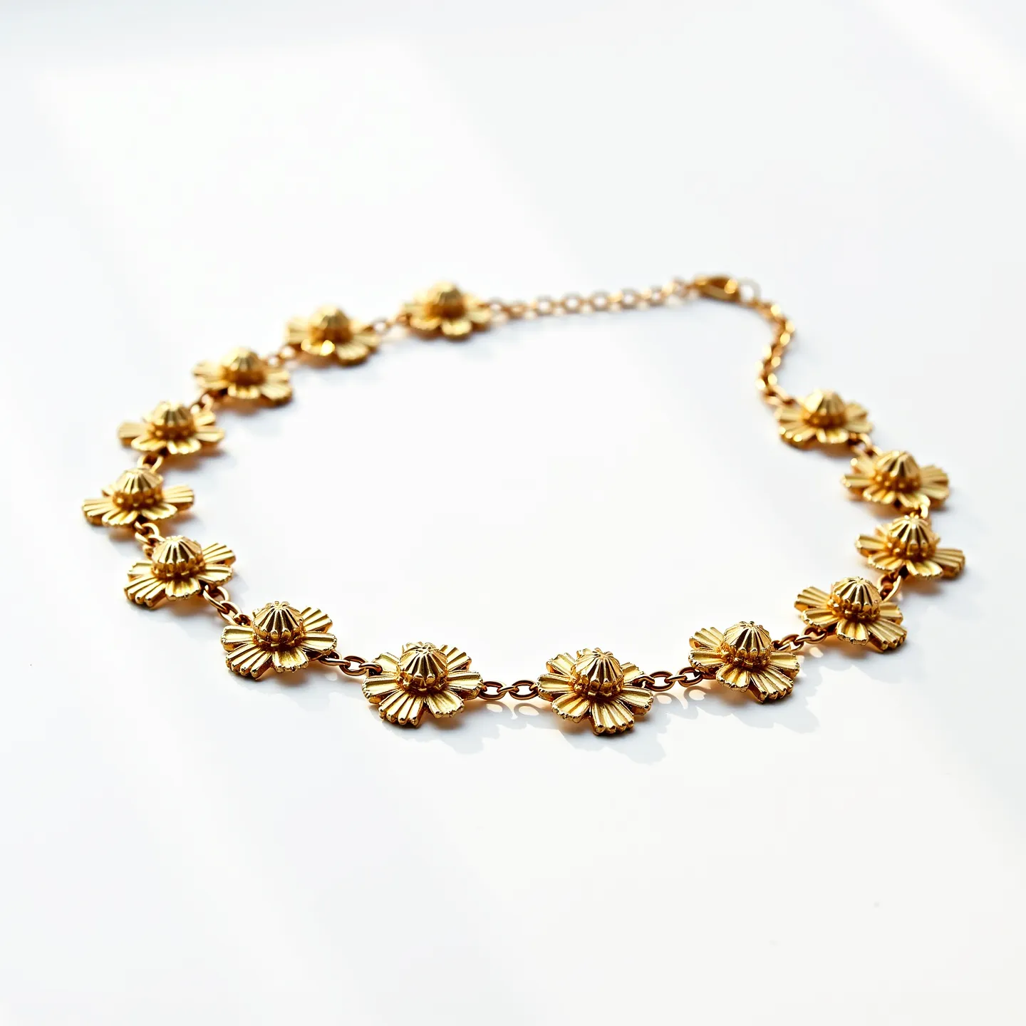 This gold flower necklace features a series of intricately designed floral motifs arranged along a delicate chain. Each flower appears to be crafted from gold, showcasing fine detailing on the petals that gives a textured appearance. The flowers are uniformly distributed, providing a harmonious and balanced aesthetic. The necklace is secured with a small lobster clasp, which offers both functionality and subtlety, allowing the design to remain as the focal point. The overall craftsmanship highlights a blend of elegance and attention to detail, making it a striking piece of jewelry.