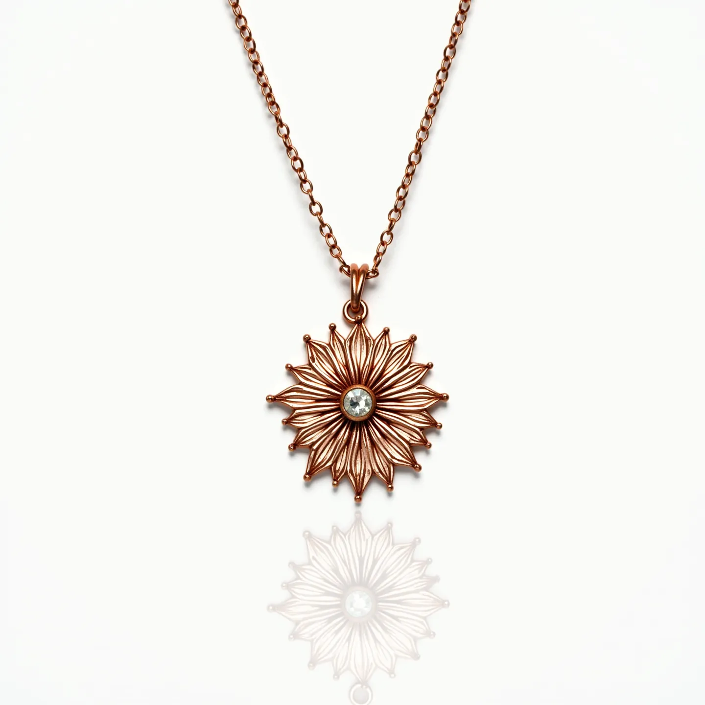 This gold flower necklace features a finely crafted floral pendant design, intricately detailed with a warm gold tone that highlights its delicate petals. At the heart of the flower sits a clear gem, likely a round-cut diamond or cubic zirconia, that is skillfully set in a bezel setting, providing a refined sparkle and secure placement. The necklace is elegantly suspended from a simple yet sturdy chain that complements the pendant's elegance. It is secured with a classic lobster clasp, ensuring both functionality and style in its overall design.