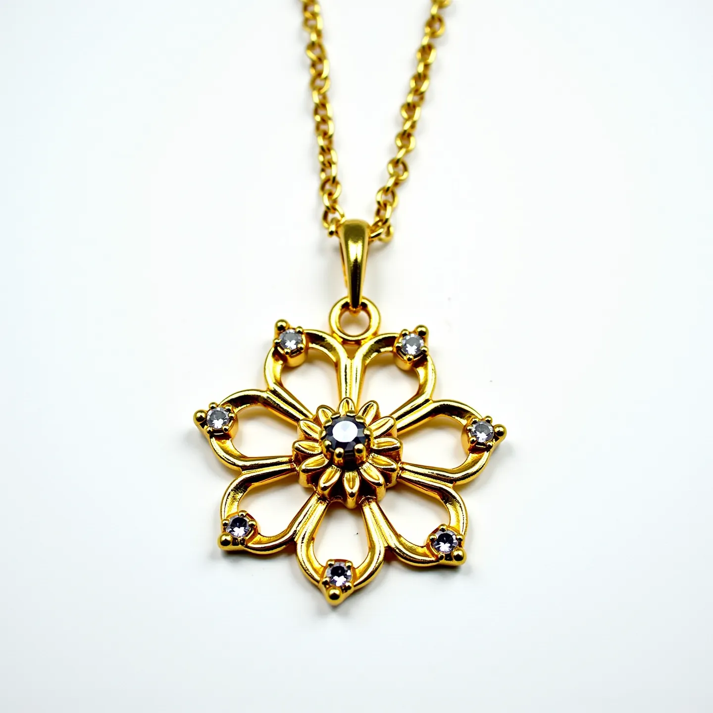 This gold flower necklace features an intricately designed floral pendant crafted from high-quality gold. The pendant showcases a central flower motif, elegantly enhanced by the placement of small, sparkling stones set in a round brilliant cut at each petal tip, as well as one at the center, adding a touch of sophistication. The stones are securely set in prong settings, ensuring they catch the light beautifully. The necklace chain is a classic link chain, complementing the pendant's elegance. The necklace is finished with a lobster clasp, providing a secure and easy-to-use attachment method.