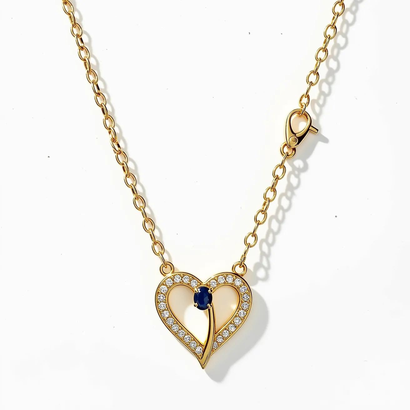 This gold heart necklace features a delicate heart-shaped pendant crafted from a warm, golden metal. The pendant is adorned with an array of small, sparkling stones, likely diamonds, which are set in a beautiful pavé setting, enhancing the shine and elegance of the piece. At the center of the heart, a larger, deep blue gemstone, possibly a sapphire, is elegantly placed in a prong setting, adding a striking contrast. The necklace is completed with a fine gold chain and features a heart-shaped spring ring clasp, ensuring both style and security.