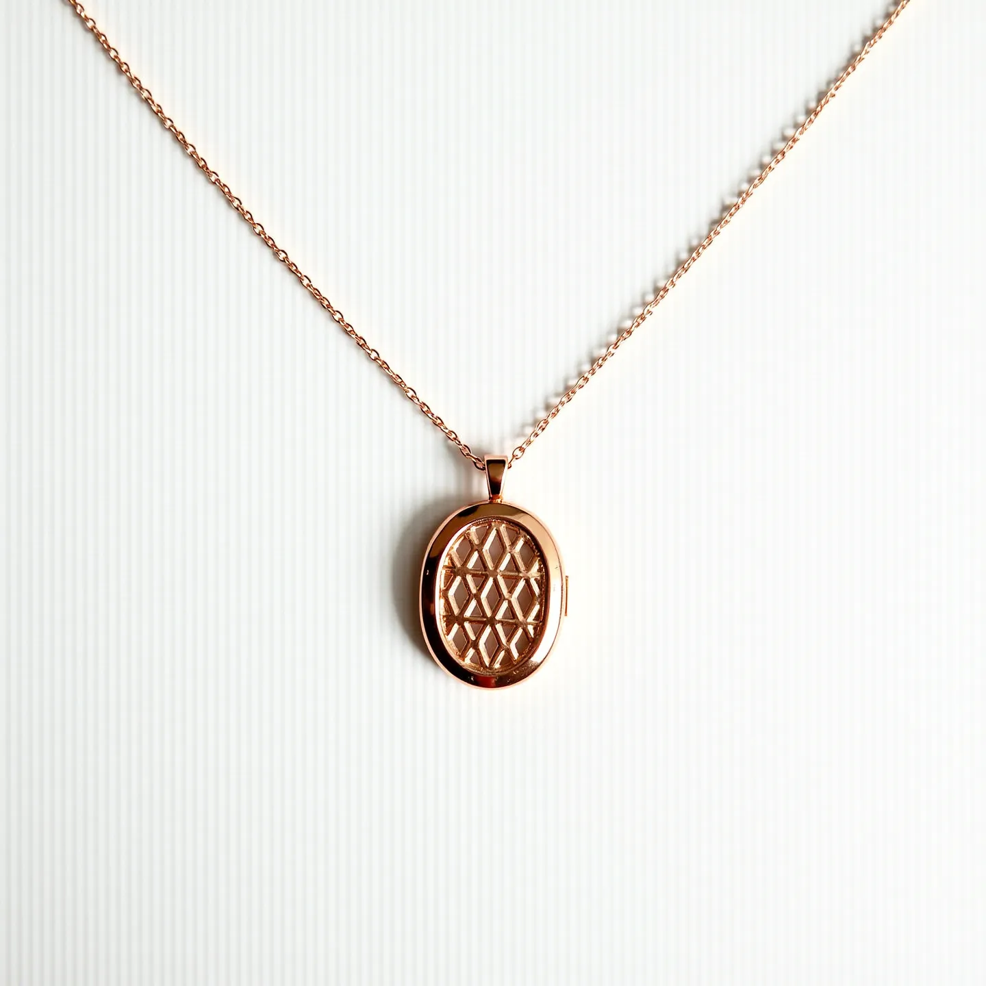 This gold locket necklace features an elegant oval-shaped locket highlighted by an intricate diamond lattice pattern on its surface. The locket is crafted from gold, exuding a warm, luxurious sheen that enhances its classic design. It is attached to a delicate gold chain, which complements the pendant's simplicity and sophistication. The necklace includes a discreet hinge and a small latch on the side, allowing the locket to open and close securely, perfect for holding cherished keepsakes or photographs. The design emphasizes both functionality and timeless style, making it a versatile accessory.