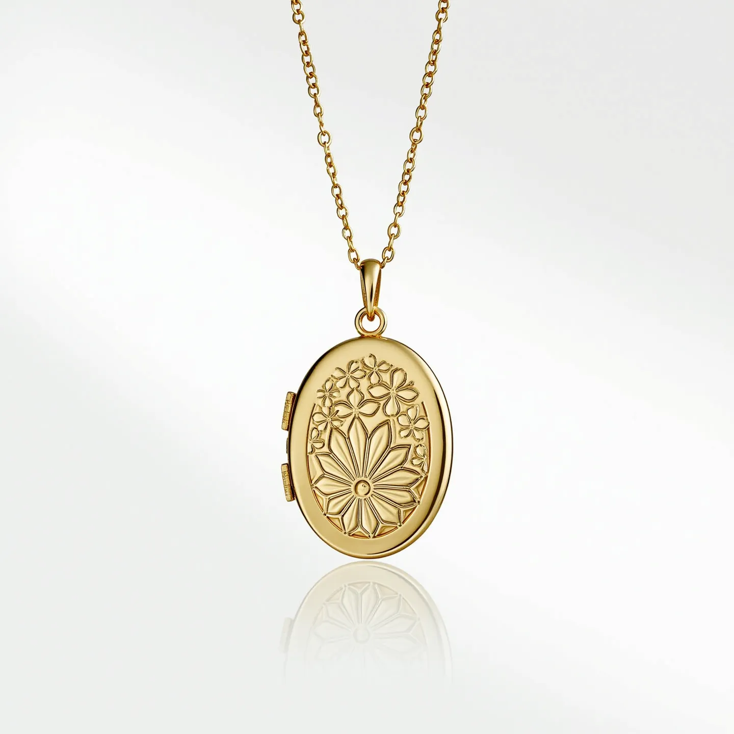 This gold locket necklace features an oval-shaped pendant crafted from gold with an intricate floral design embossed on the front. It is suspended from a delicate gold chain, which appears to have a simple yet elegant design. The locket likely opens to reveal space for personal mementos or photos, though this is implied by its locket style. The piece is finished with a small, polished gold clasp, ensuring both functionality and aesthetic appeal. The combination of the floral motif and the smooth gold surface highlights the locket's classic elegance and timeless design.