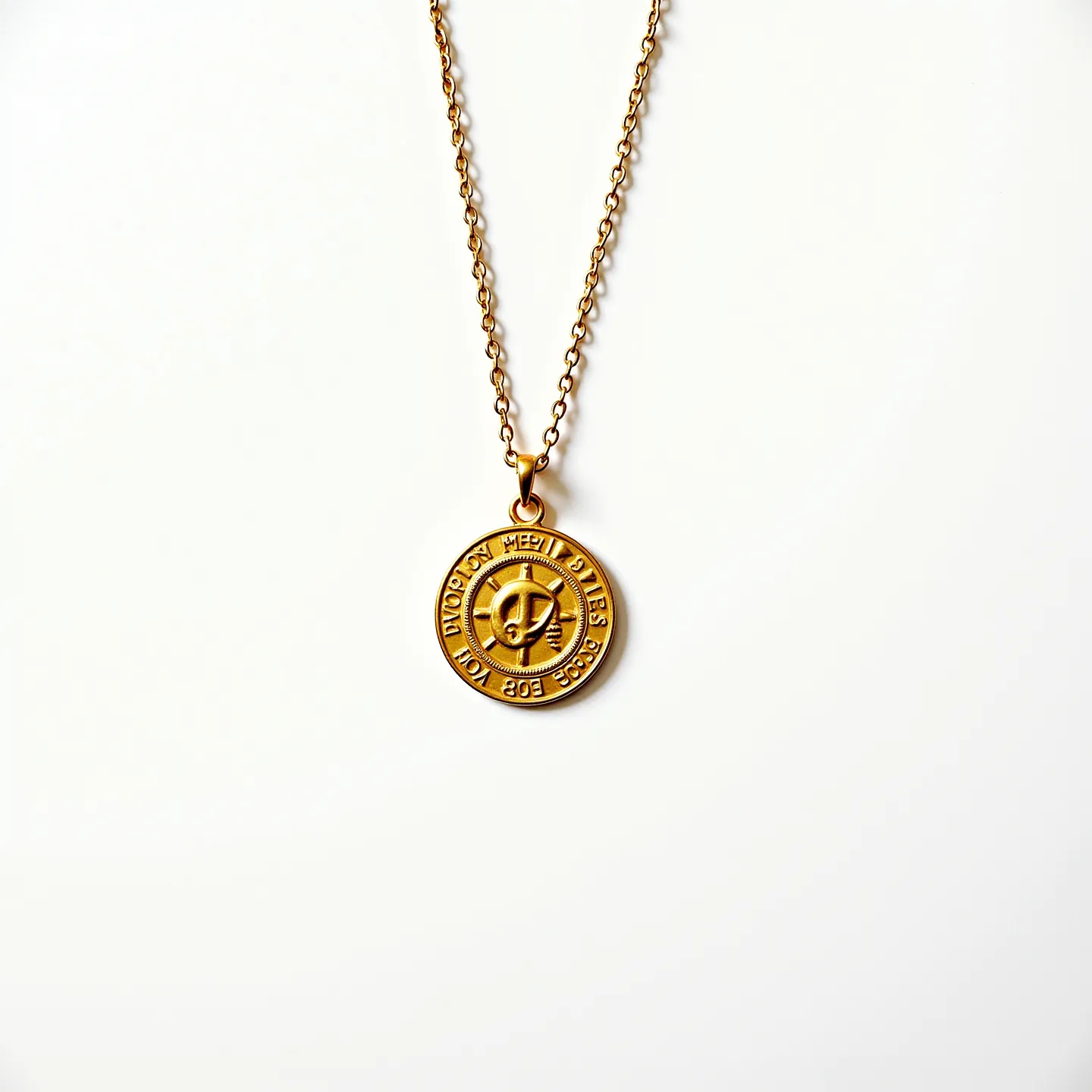 This gold medallion necklace features a round medallion crafted from gold, which hangs from a matching gold chain. The medallion displays embossed lettering encircling a central design, suggesting an intricate, detailed appearance. The chain consists of interconnected links, typical of a classic chain design that complements the medallion's elegant style. The attachment of the medallion appears to be a simple bail, ensuring secure connection to the chain. The overall design highlights the medallion as the focal point, emphasizing its detailed craftsmanship without the inclusion of additional gemstones or complex settings.