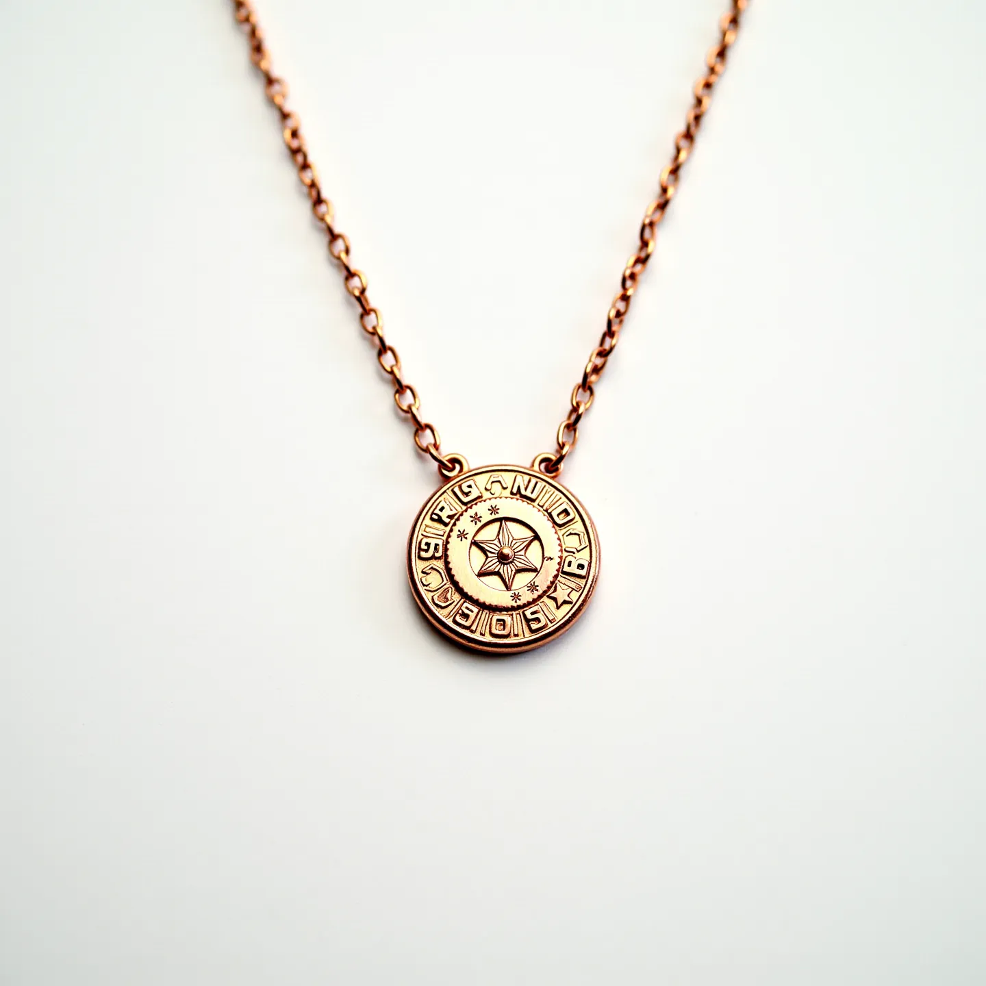 This gold medallion necklace features a round, intricately designed pendant made of polished gold. The medallion displays a central star motif surrounded by engraved letters and small star symbols, contributing to its ornate appearance. The necklace chain is composed of fine gold links, offering both elegance and durability. The pendant is seamlessly attached to the chain, creating a cohesive and stylish piece. The necklace likely includes a standard spring ring clasp for secure fastening, enhancing its practicality and wearability.