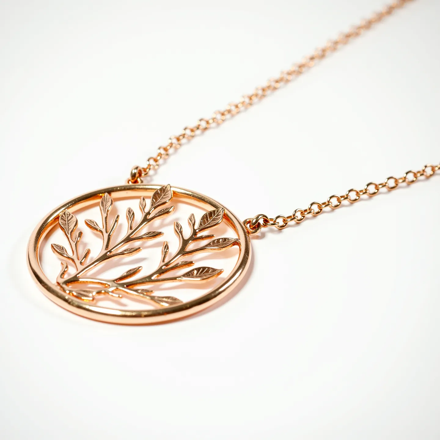 This gold medallion necklace features a delicate circular pendant crafted from polished gold, intricately designed with a pattern of leaves and branches. The pendant is suspended from a fine chain also made of gold, which connects seamlessly to either side of the medallion. The necklace showcases artisan craftsmanship with its detailed, nature-inspired motif, and is likely secured with a typical clasp, ensuring easy wearability. The overall design emphasizes elegance and simplicity, making it a versatile piece suitable for various occasions.