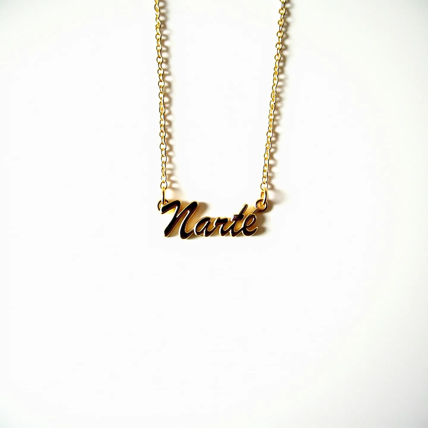 This gold name necklace features a delicate chain linked to an ornate, cursive-style pendant that spells out the name “Narte.” The gold material gives it a classic and luxurious look, with a smooth, polished finish that catches the light elegantly. The necklace has an understated elegance, with no visible gemstones or intricate settings, emphasizing the beauty of the gold itself. It is attached by a subtle loop mechanism at each end of the nameplate, seamlessly integrating into the chain for a cohesive design.