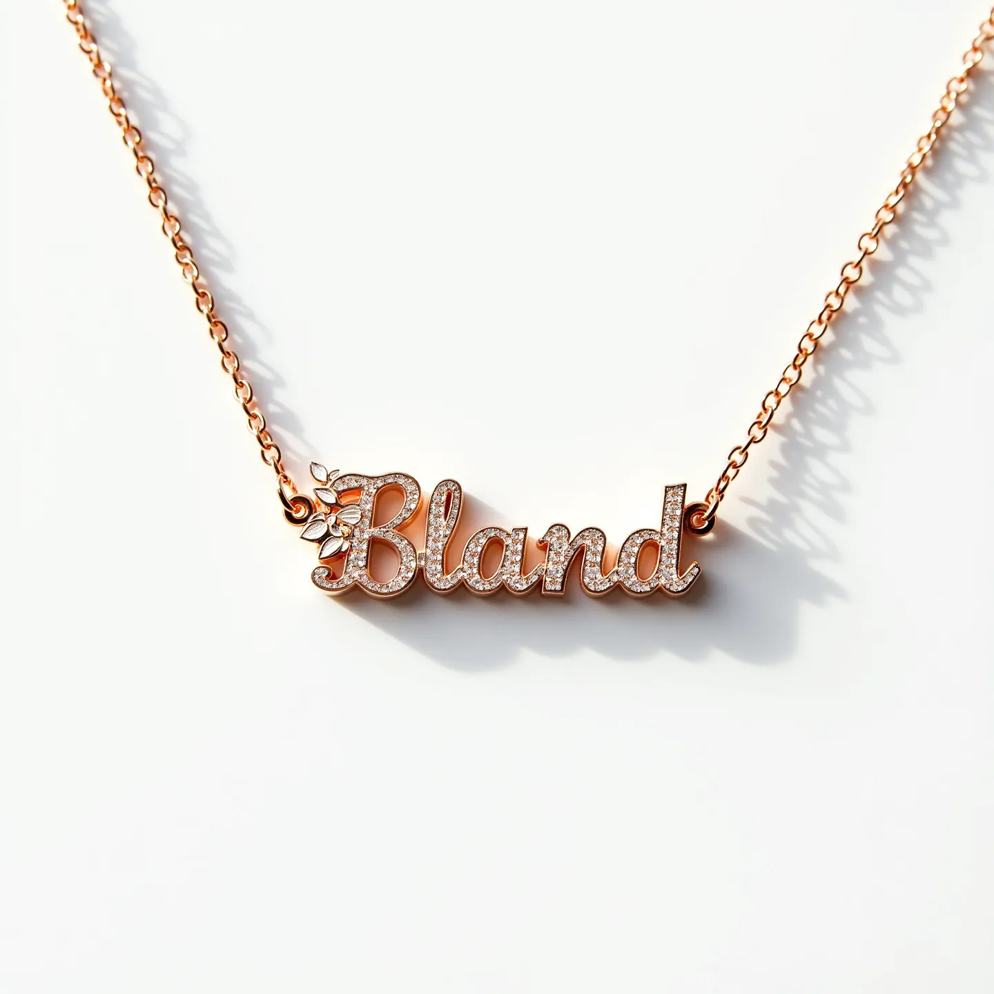 This gold name necklace features a cursive "Bland" crafted from a warm-toned gold. The letters are adorned with small, round-cut gemstones, possibly diamonds, which are set in a pavé style, adding a sparkling detail to the piece. The necklace also includes a delicate floral motif near the letter "B," incorporating additional accent stones that enhance the overall design with a touch of elegance. The chain is fine and links gracefully into either side of the name plate, likely secured with a standard clasp, ensuring both style and security in wear.