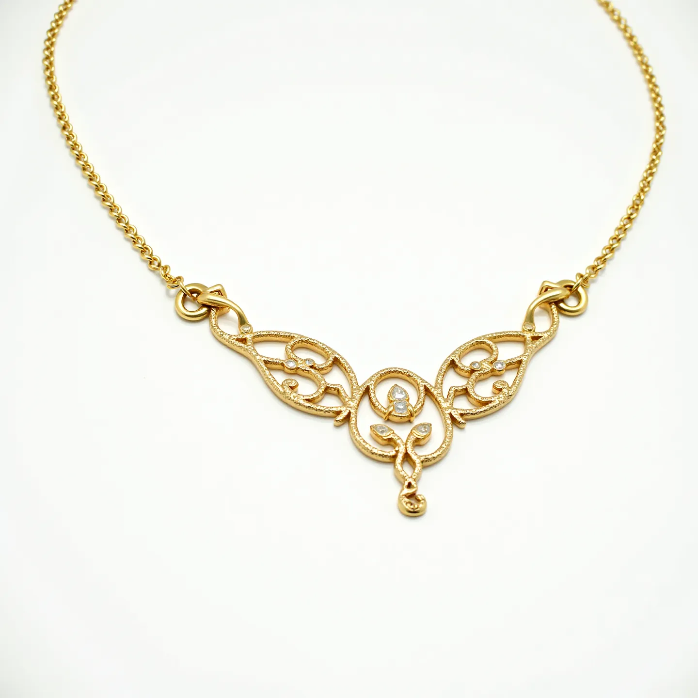 This gold necklace features an intricate ornamental design crafted from high-quality gold, displaying a combination of openwork scrolls and floral motifs. At the center, three small, round-cut diamonds are set in a triangular arrangement, adding a touch of sparkle to the piece. The diamonds are securely held in place through a prong or bezel setting, reflecting careful craftsmanship. The necklace is completed with a sturdy chain and a classic lobster clasp, ensuring both style and safety in wearing.