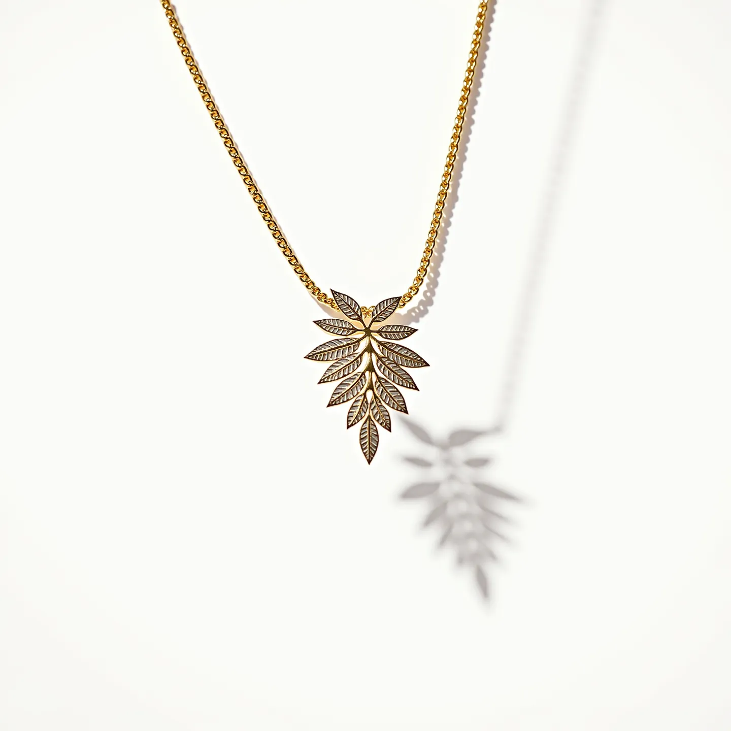 This gold necklace features a delicate chain that supports an intricately designed pendant shaped like a cluster of leaves. The pendant is crafted with detailed engraving to mimic leaf patterns, showcasing fine artistry. Each leaf element is adorned with small, clear gems that appear to be round-cut diamonds, adding a subtle sparkle to the piece. The stones are set in a manner that allows them to catch the light elegantly. The clasp appears to be a classic lobster clasp, ensuring both security and ease of wear. The combination of gold and sparkling stones gives the necklace a luxurious yet nature-inspired aesthetic.