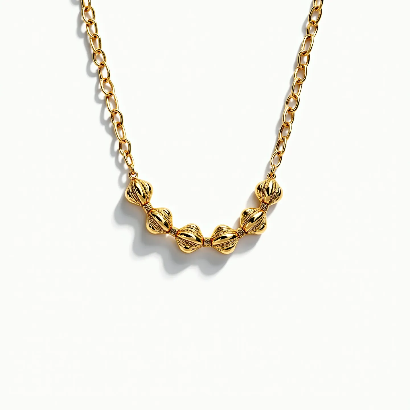 This gold necklace features a series of intricately designed, gold-toned beads with a carved, ribbed texture that adds a touch of elegance and complexity. The beads are symmetrically arranged along the central portion, creating a balanced look. The chain consists of interlinked oval links, providing a classic and timeless appeal. The necklace likely utilizes a standard lobster clasp, ensuring a secure fit around the neck. The craftsmanship of the necklace highlights both modern design and traditional elegance.