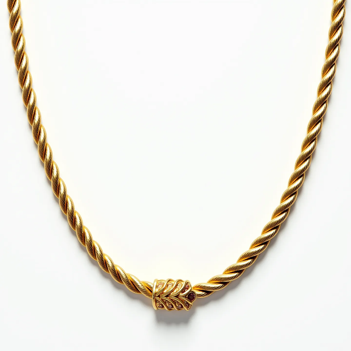 This gold rope necklace features a twisted, braided design, creating a textured appearance that enhances its luxurious aesthetic. Composed primarily of gold, the necklace exudes a warm, radiant sheen. In the center, there is a decorative element that follows the necklace’s twisted pattern, contributing to the overall elegance of the piece. The clasp is seamlessly integrated into the design, maintaining the uniform appearance characteristic of fine jewelry. The necklace combines craftsmanship and style, embodying both sophistication and timelessness.