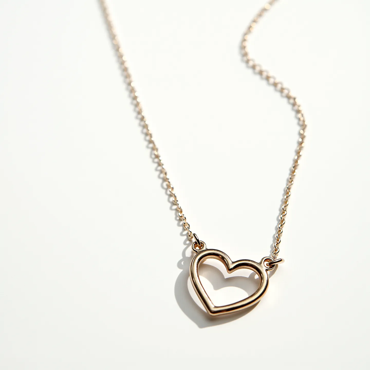 This heart chain necklace features a delicate metal chain with a heart-shaped pendant crafted from what appears to be gold or gold-toned material. The heart design is simple and elegant, showcasing a smooth and polished finish without any visible embellishments or gemstones. The necklace is likely secured by a standard clasp, ensuring ease of wear and removal. The overall aesthetic is minimalist, emphasizing the graceful heart motif as the focal point.