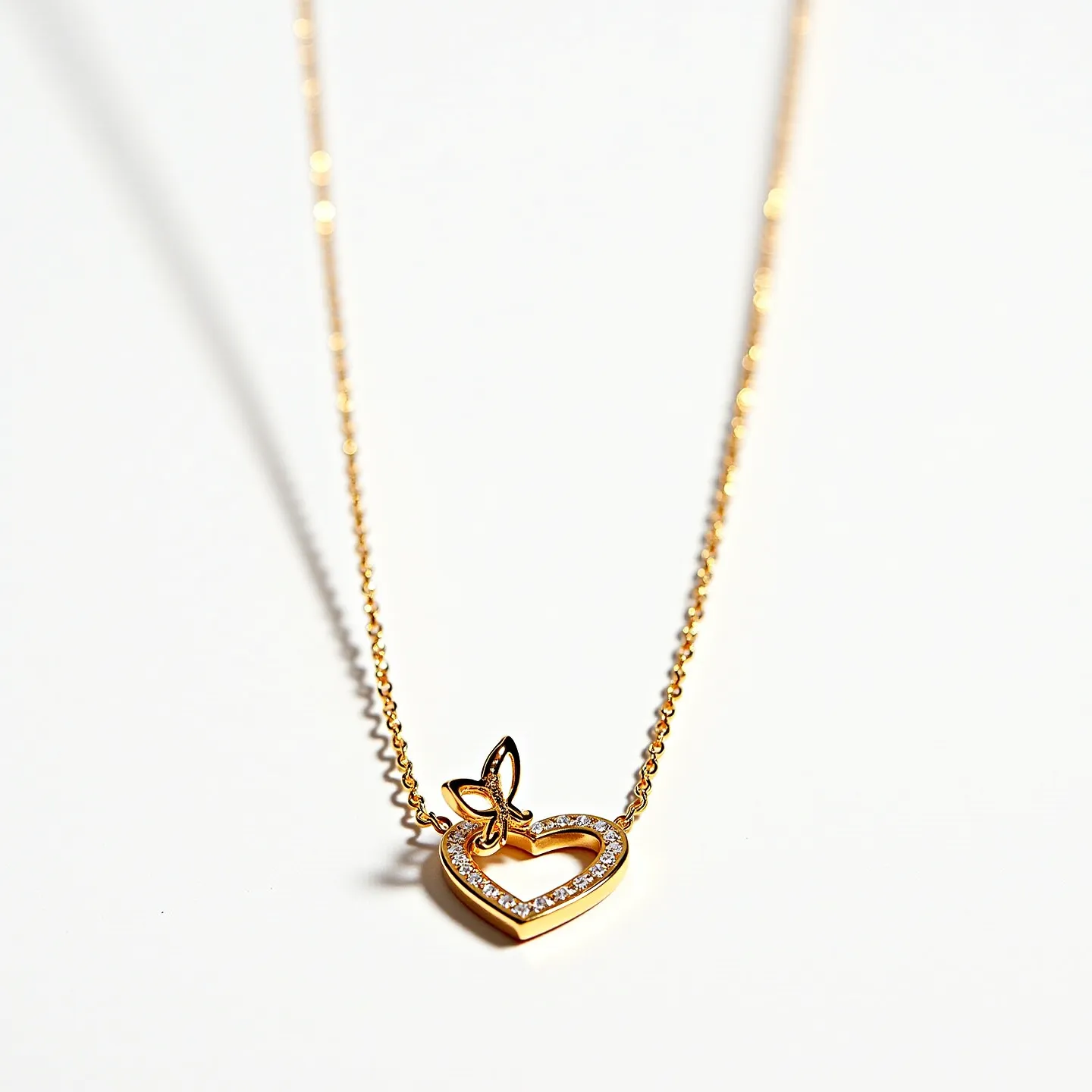 This heart chain necklace features a delicate gold chain, supporting a heart-shaped pendant adorned with small, round diamonds set in a pave setting, enhancing its sparkle. The heart also has a small butterfly detail attached to the top, adding an extra element of charm and intricacy to the design. The necklace is secured with a simple lobster clasp, ensuring both ease of use and security. The overall craftsmanship highlights a blend of elegance and modern design, making it suitable for various occasions.