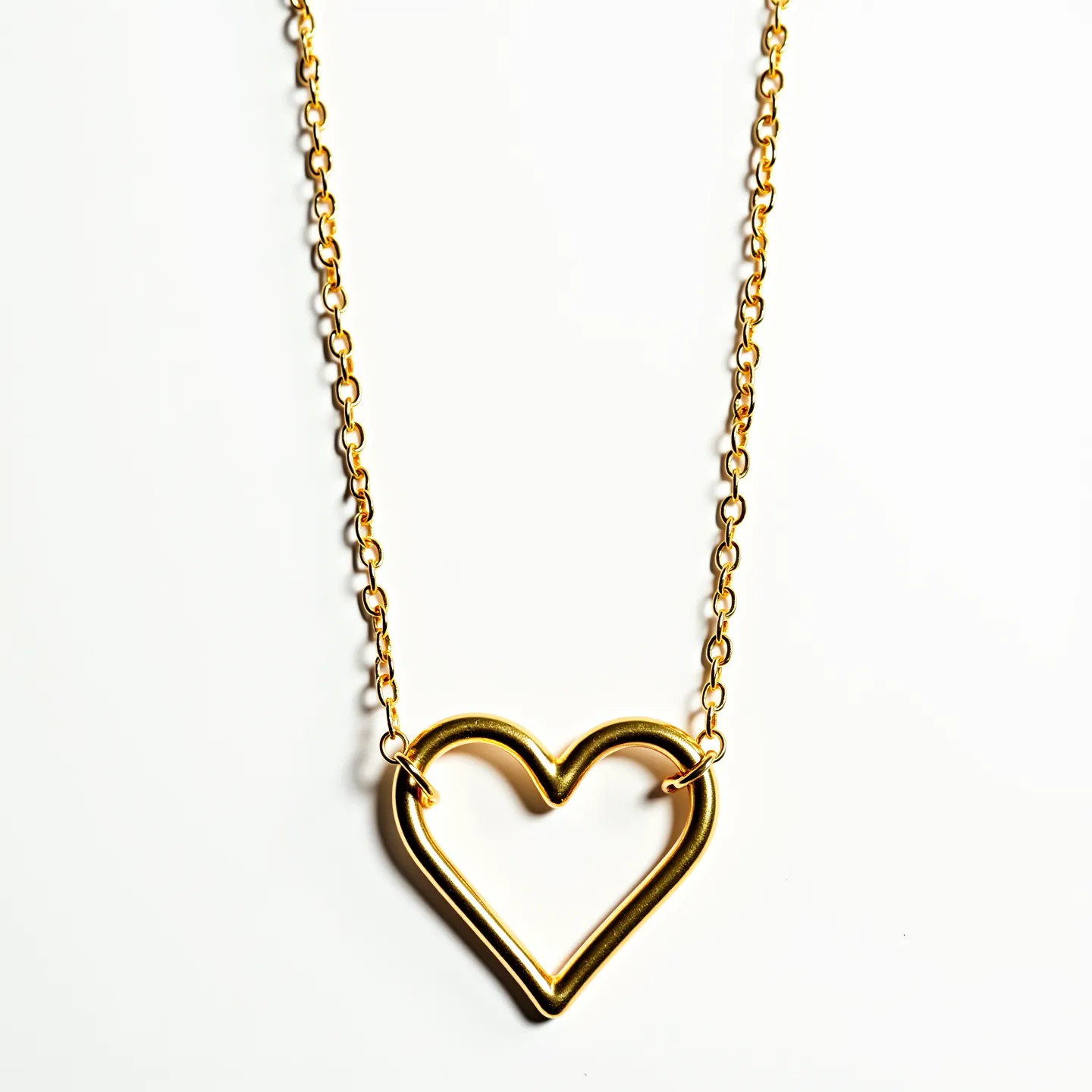 This heart chain necklace features an elegant and simple design, characterized by a metallic heart-shaped pendant integrated into a delicate chain. The material appears to be gold or gold-toned metal, lending the necklace a classic and luxurious appearance. The heart pendant is seamlessly connected to the chain, which consists of small, evenly spaced links, ensuring both durability and aesthetic appeal. The necklace does not visibly showcase any gemstones, focusing instead on the pure metallic design for its understated beauty. It likely includes a standard clasp for attachment, providing secure and easy fastening.