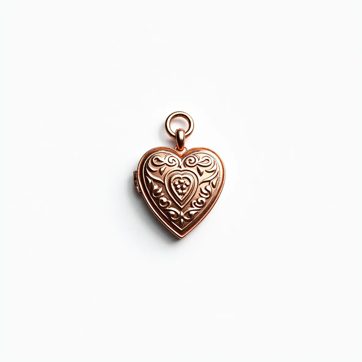 This heart locket is crafted from a metal that has a warm, golden hue, suggesting it might be rose gold or a similar alloy. It features an intricate embossed design on its front, showcasing elegant scrollwork and a central heart motif with a textured cluster that resembles small beads. The locket is equipped with a simple loop and jump ring at the top, allowing for easy attachment to a chain. Its ornate detailing gives it a vintage or romantic aesthetic, making it both a personal accessory and a sentimental keepsake.