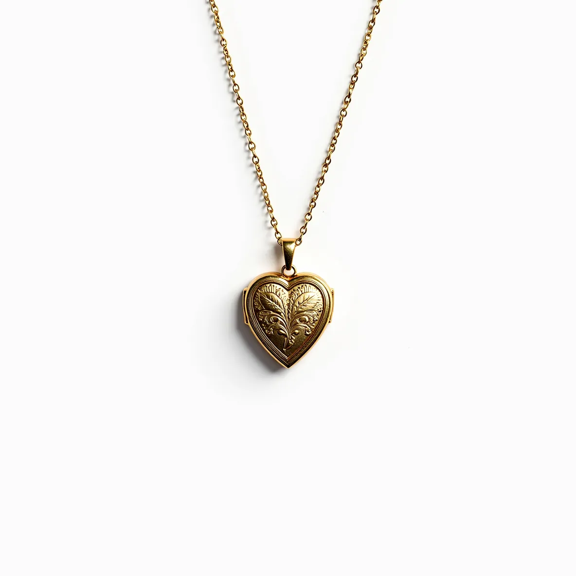 This heart locket is crafted from a gold-toned metal, presenting a polished and elegant appearance. It features intricate engraved designs on both halves of the heart, adding a touch of vintage charm. The locket is suspended from a delicate chain, connected by a small loop at the top of the heart, ensuring secure attachment. The hinged design allows the locket to open, commonly used to enclose small, cherished photographs or keepsakes. Overall, this piece combines elegance with sentimental value, making it a classic choice for personal jewelry.