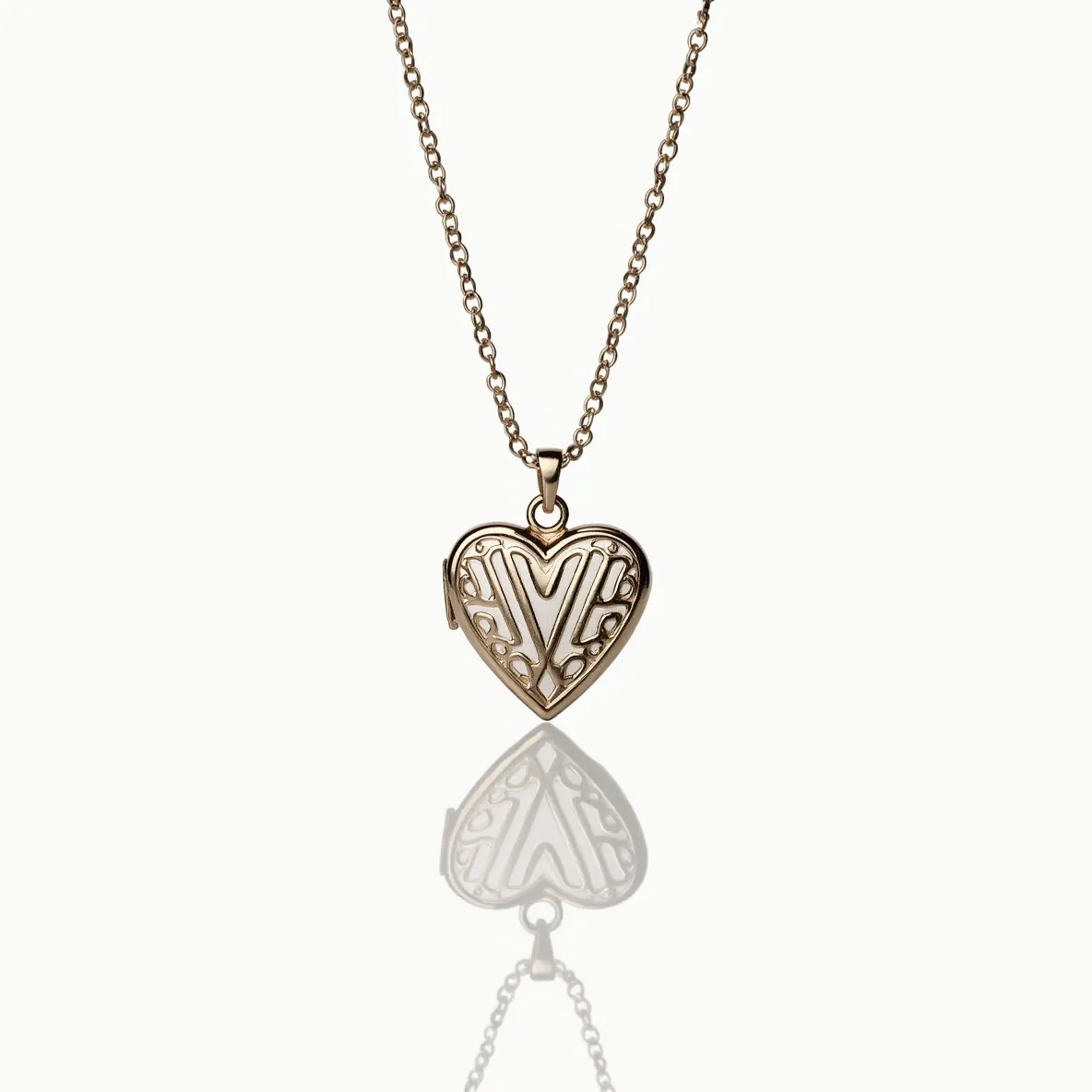 This heart locket features an intricate design, likely crafted from a warm-toned metal such as gold or gold-plated material, lending it a classic and timeless appeal. The front of the locket showcases an elegant, filigree-like pattern, adding depth and texture to its appearance. The locket is suspended from a matching chain, attached by a simple yet elegant bail that allows for smooth movement. While the main focus is the locket's ornate facade, its construction suggests a functional clasp mechanism to open and close the heart, indicating its purpose as a keepsake. The overall design exhibits a blend of elegance and delicate craftsmanship.