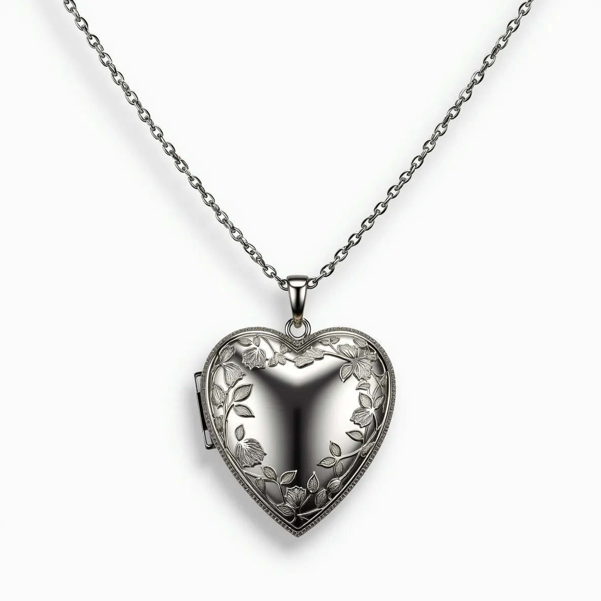 This heart locket is crafted from a metallic material, displaying a polished surface with an intricate floral engraving that elegantly frames its rounded shape. The locket opens via a discreet hinge on one side, allowing for personal keepsakes or photos to be stored inside. It features a bail at the top, through which a delicate chain is threaded, ensuring secure wear. The chain itself is composed of interlocking links that complement the locket’s design, providing a cohesive and timeless aesthetic.