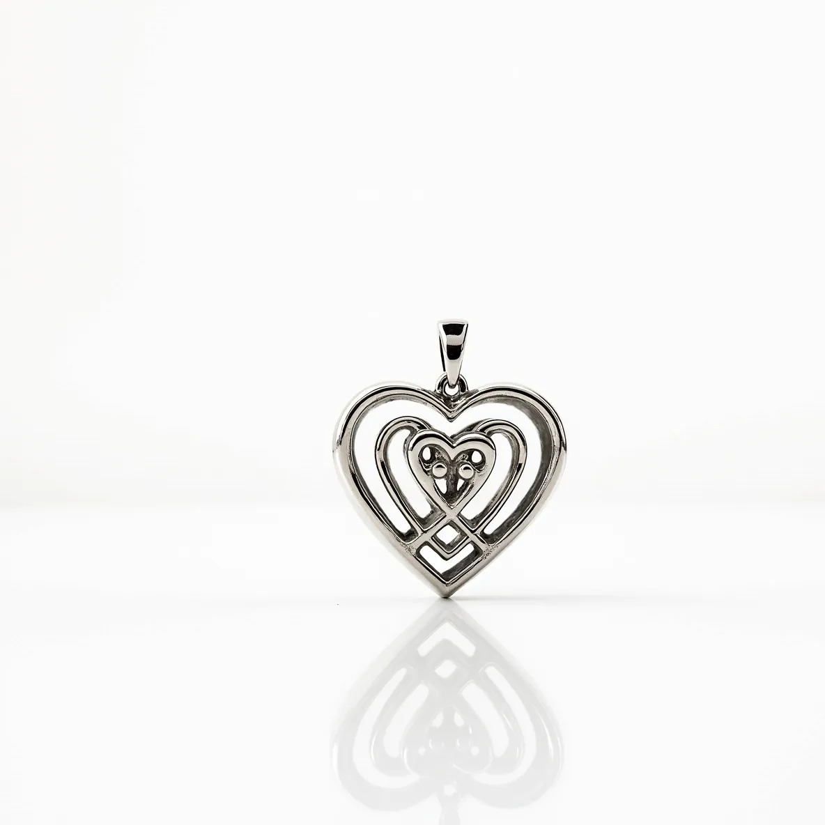 This heart locket features an intricate design made of a shiny silver-toned metal. It comprises a series of interlocking hearts, giving it a layered and visually appealing look. At the center of the smallest heart, there are three small stones, possibly diamonds or cubic zirconia, each set in a bezel style that complements the overall delicacy of the locket. The locket is equipped with a simple bail attachment at the top, allowing it to easily connect to a necklace chain. The craftsmanship highlights elegance through its smooth curves and meticulous attention to detail.