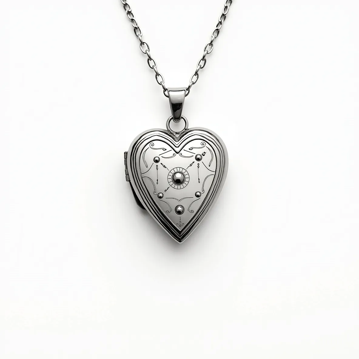 This heart locket is crafted from a polished silver-toned metal, giving it a sleek and modern appearance. The surface is adorned with intricate, symmetrical engravings that enhance its visual appeal. At the center, a round gem is set, featuring a cabochon cut that adds smoothness and depth, surrounded by a delicate circle of metalwork that resembles a bezel setting. The locket is attached to a chain through a small circular bail, allowing it to hang elegantly. The clasp appears to be a standard hinge type, securing the locket's contents safely within.