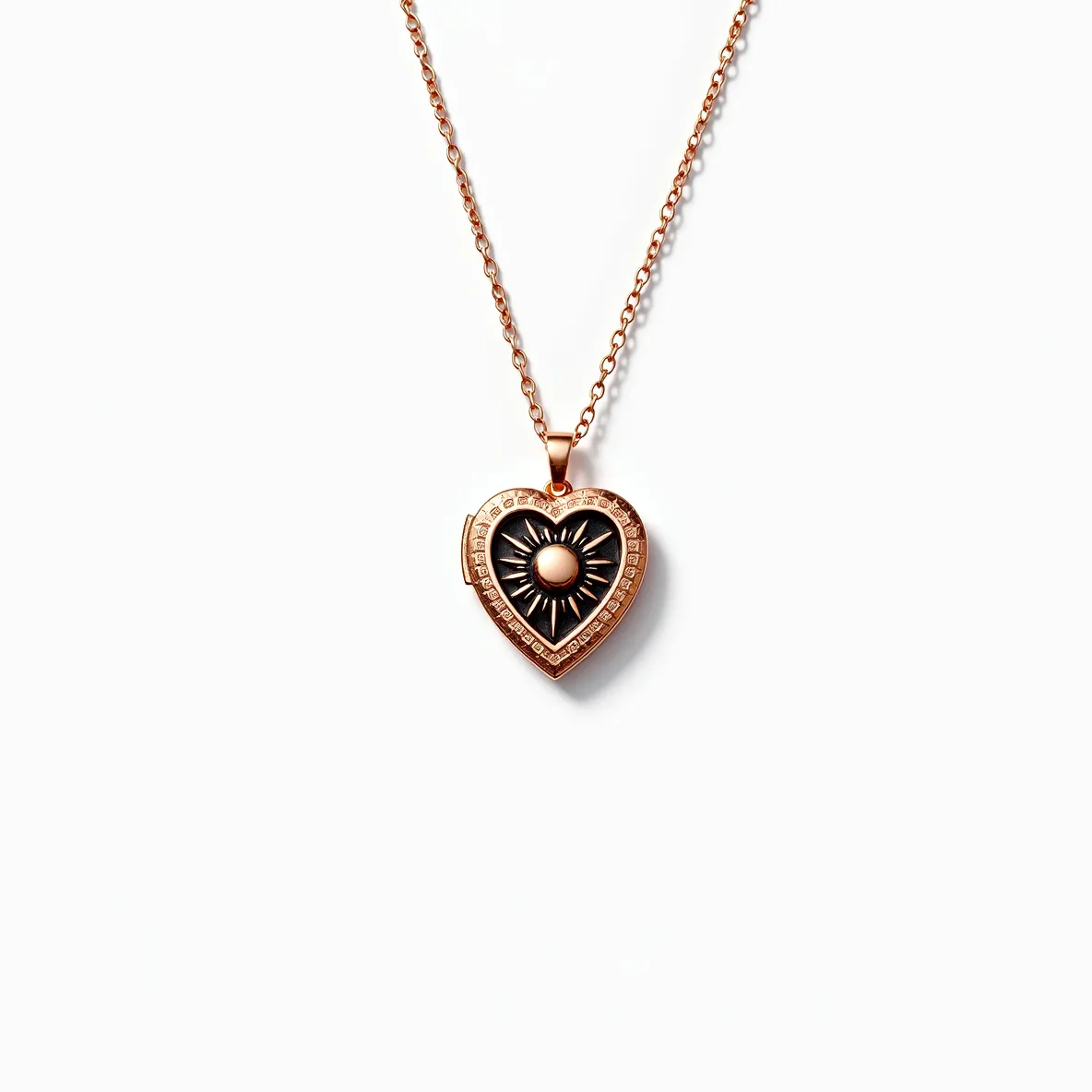 This heart locket features a rose gold-toned metal, giving it a warm and elegant appearance. The front design showcases an intricate sunburst pattern with a central smooth, round gem that resembles a pearl, adding a subtle touch of sophistication. Surrounding the centerpiece are small, clear stones, possibly diamonds or cubic zirconia, set in a pave style that enhances the locket's sparkle and detail. The locket is attached to a delicate rose gold chain with small, interlocking links, ensuring the piece is both sturdy and graceful. The clasp is a standard lobster clasp, providing secure and easy fastening.