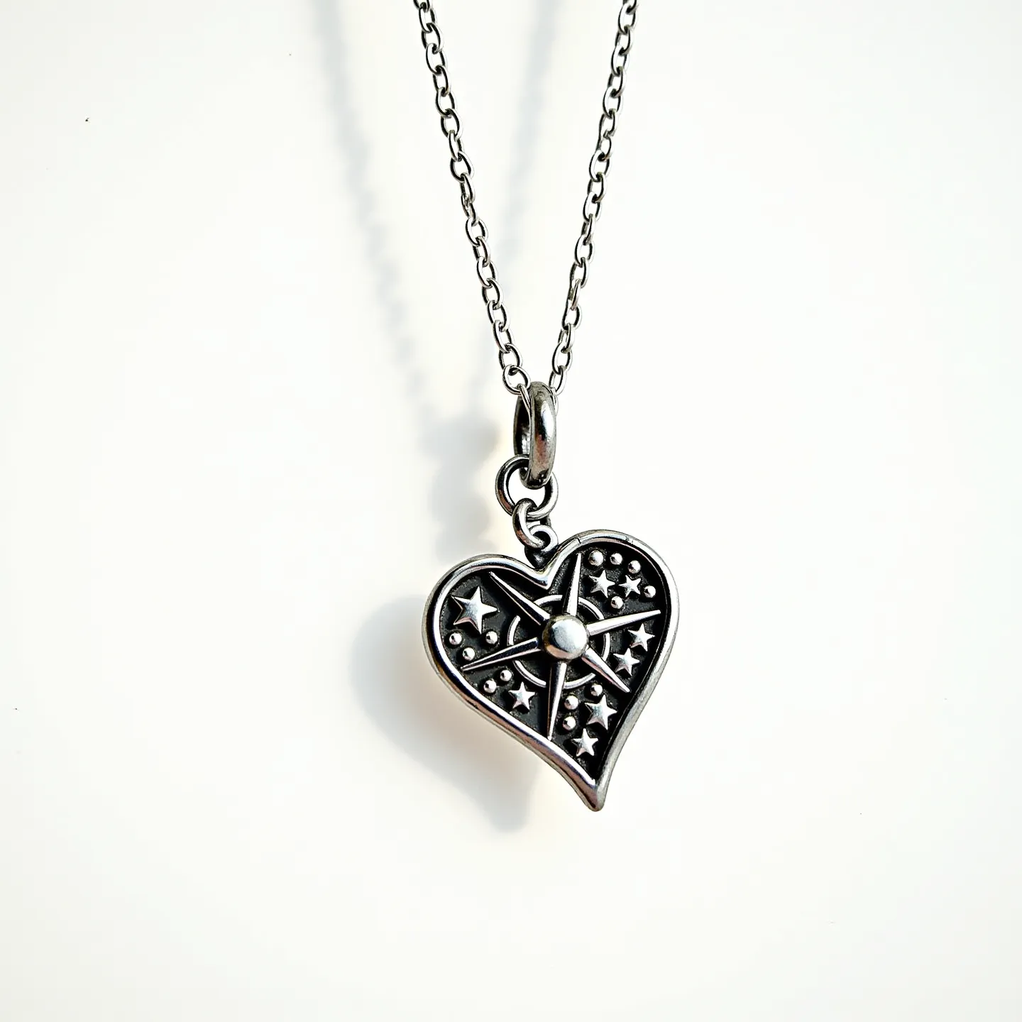 This heart necklace features a pendant made of a silver-toned metal, intricately designed with star-shaped cutouts and a central circular accent, giving it a stellar motif. The pendant is attached to a delicate chain, which is likely crafted from the same material, with a typical link design that complements the overall aesthetic. The clasp or attachment detail is not visible, but the pendant hangs from a small loop, ensuring it stays securely on the chain. The craftsmanship suggests a balance of elegance and whimsy, suitable for casual or formal wear.