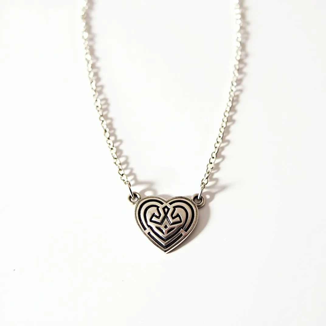 This heart necklace features a metal pendant with an intricate, maze-like design in a classic heart shape. The pendant is crafted from what appears to be silver-toned material and is attached symmetrically to a delicate chain, matching the color and finish of the heart. The chain is composed of small, evenly spaced links that provide a subtle yet secure attachment without any visible gemstones or embellishments. The necklace likely closes with a standard clasp, integrated seamlessly into the chain's design, ensuring it remains both understated and elegant.