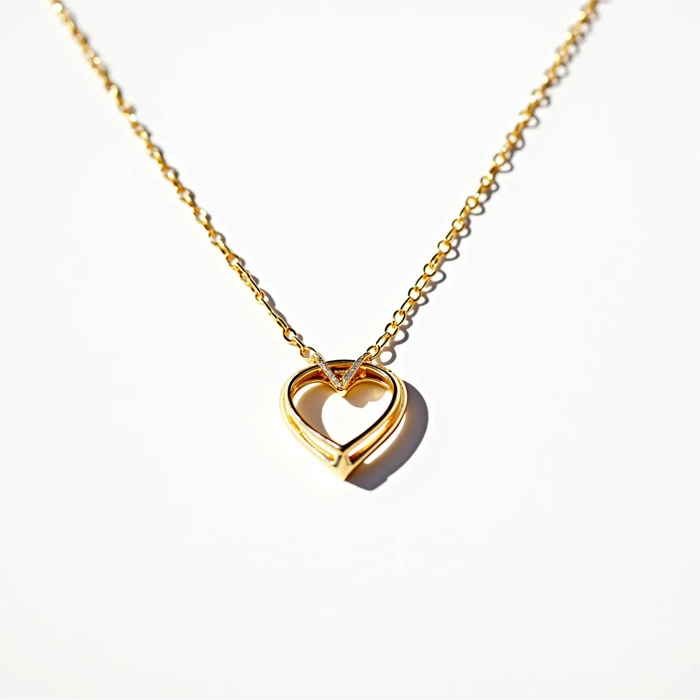 This heart necklace features a delicate gold chain with a pendant designed in an open-heart shape. The pendant appears to be crafted from polished gold, showcasing a smooth, elegant finish. The subtle V detail at the top of the heart adds a modern touch to the design. This pendant is attached to the chain without visible prongs or settings, enhancing its minimalist appeal. The chain likely closes with a standard clasp, ensuring secure wearability while complementing the necklace's sleek look.