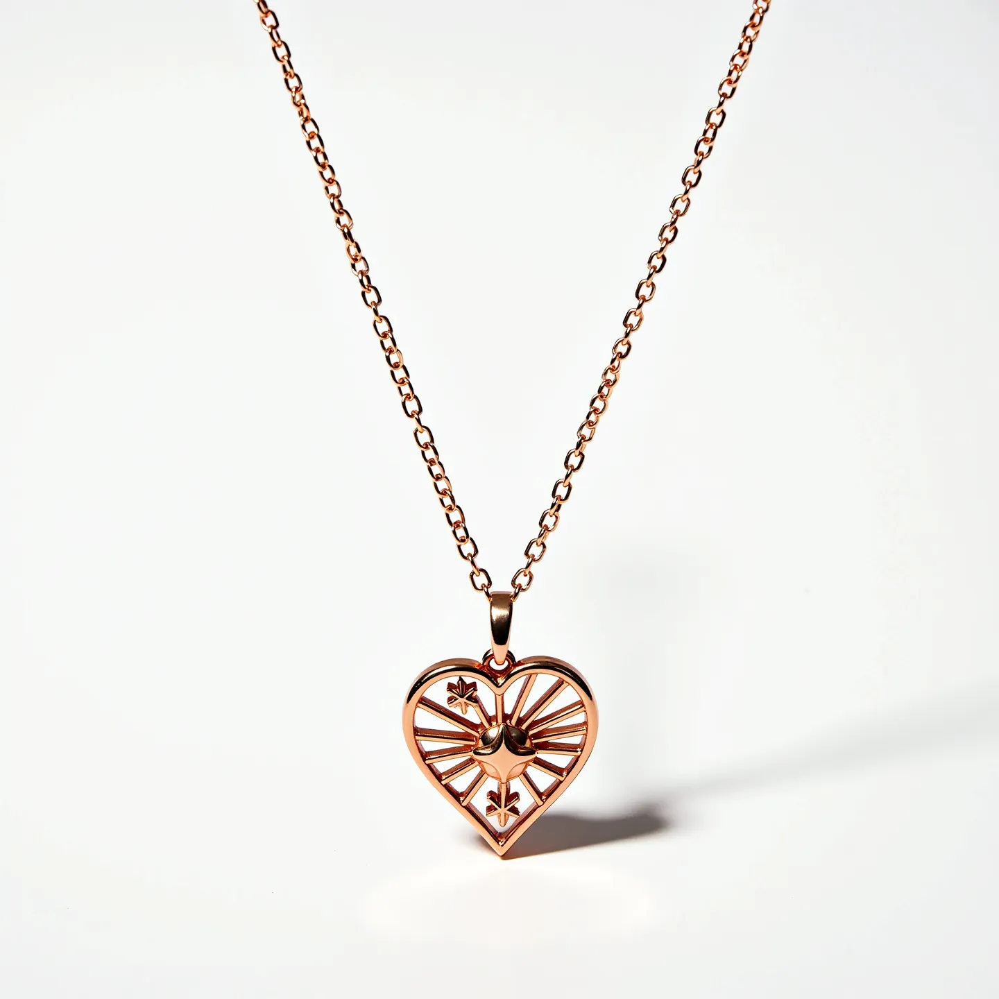 This heart necklace features a rose gold-colored metal chain and a pendant designed in a heart shape. The pendant exhibits an intricate design with cut-out sections, displaying a geometric pattern that possibly symbolizes stars or flowers. The metal appears smooth and polished, providing a shiny appearance. The chain links are uniform and moderately sized, likely contributing to its sturdiness. There is no visible stone or gem embellishment, and the pendant is attached to the chain via a standard jump ring. The necklace is likely fastened with a typical clasp mechanism for security and ease of wear.