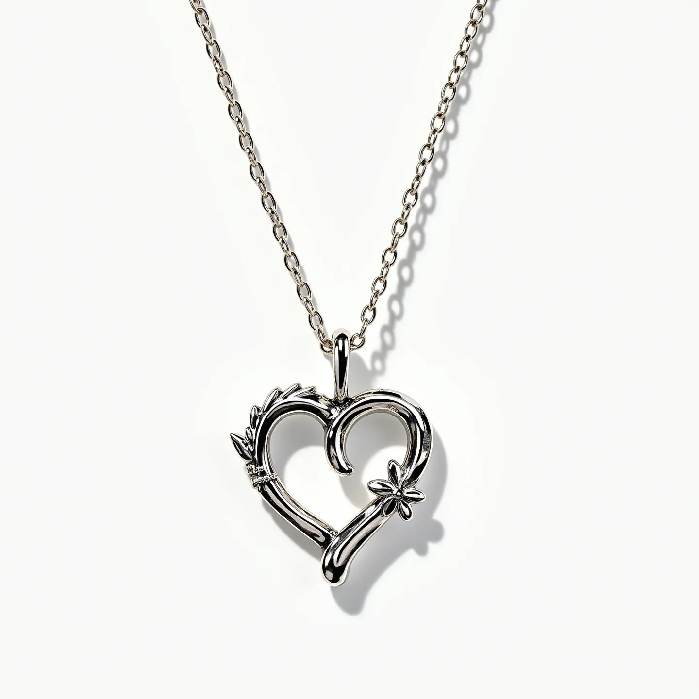 This infinity heart necklace features a beautifully crafted heart-shaped pendant that integrates the infinity symbol into its design. The piece is made of polished metal, displaying a sleek and shiny finish. The pendant is adorned with small, sparkling stones that are intricately set near the top curve, adding a touch of elegance. A delicate flower embellishment is situated on one side of the heart, enhancing its intricate design. The chain is a fine link style, adding to the necklace's delicate appearance, and it is connected to the pendant through a sturdy and elegant bale. The necklace secures with a classic lobster clasp, ensuring it stays securely fastened when worn.