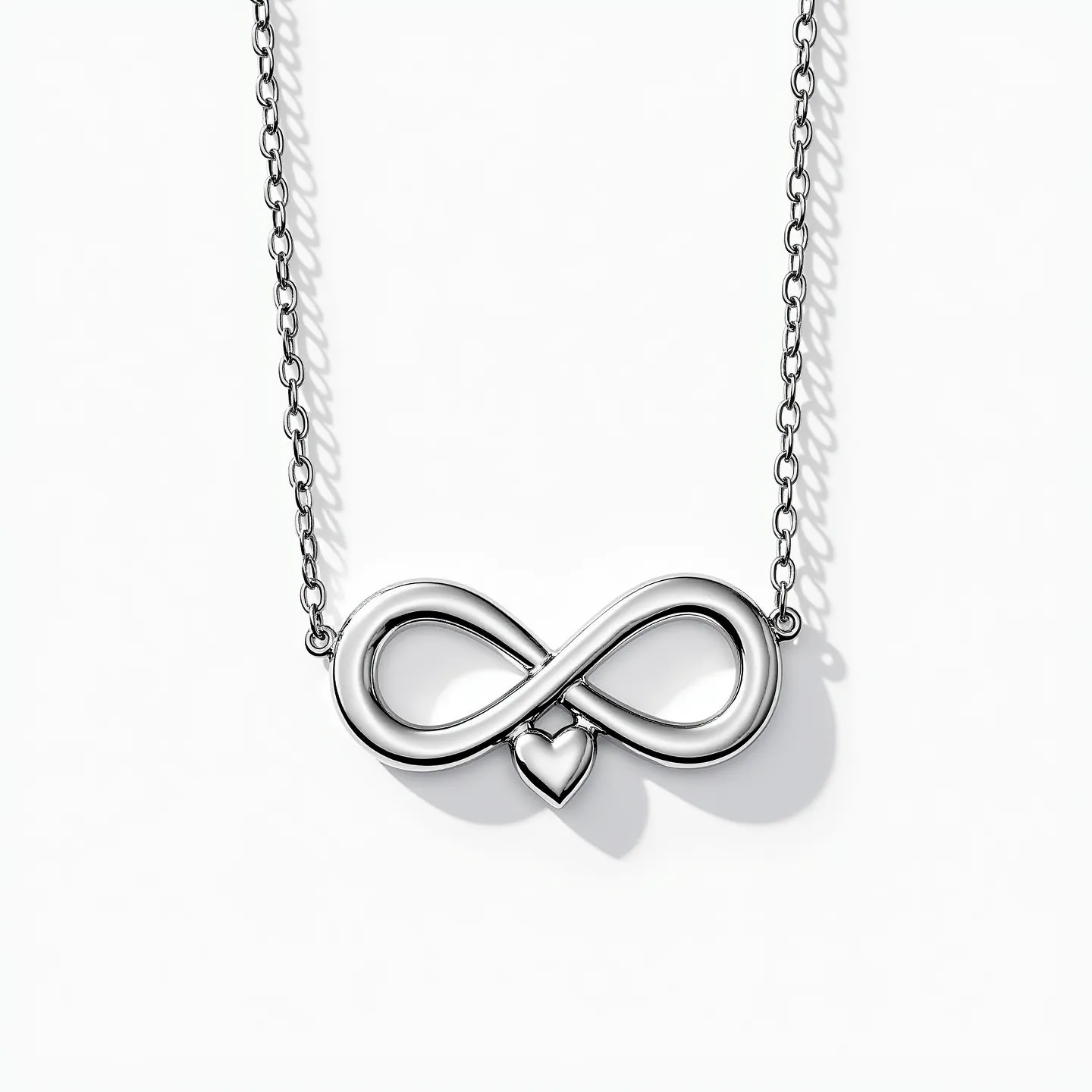 This infinity heart necklace elegantly merges the symbol of infinity with a heart, crafted from a polished silver material that reflects light beautifully. The design is simple yet meaningful, showcasing a smooth and continuous infinity loop with a heart incorporated in the lower part of the symbol. The pendant is mounted on a delicate silver chain that complements the shiny finish of the pendant itself. The necklace is secured with a classic lobster clasp, ensuring both style and functionality for everyday wear.