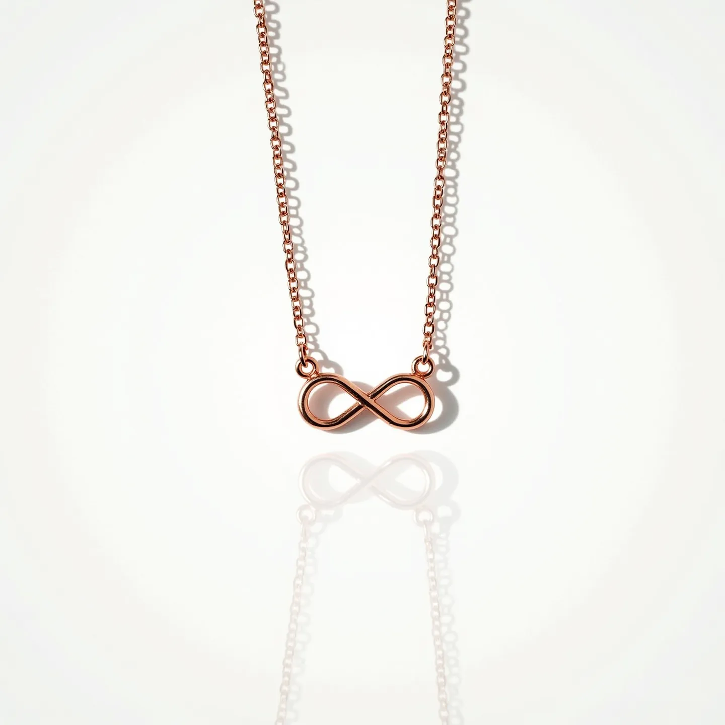 This infinity necklace features a delicate chain made of rose gold, lending it a warm, elegant appearance. The centerpiece is an infinity symbol crafted from the same material, seamlessly integrated into the chain, highlighting its timeless design. The chain has a simple, polished link style that complements the minimalistic aesthetic of the pendant. The necklace includes a lobster clasp, providing a secure and easy attachment. The craftsmanship emphasizes subtle sophistication, making it an ideal accessory for everyday wear or special occasions.