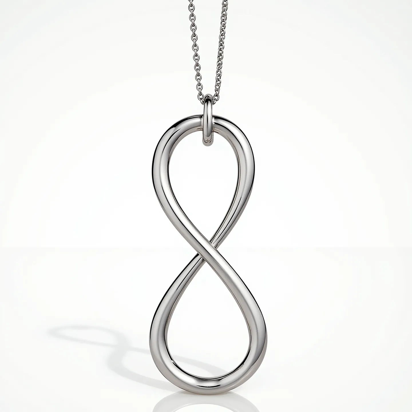 This infinity necklace features a polished metal loop forming the iconic infinity symbol, suggesting a sleek and simple design. The necklace is composed of what appears to be a high-shine metal, likely stainless steel or white gold, enhancing its elegant and modern appearance. The pendant hangs from a delicate chain, connected by a smooth, rounded bail that ensures fluid movement. The chain is finely linked, creating a subtle yet sturdy attachment for everyday wear. There are no visible gems or stones on the necklace, emphasizing its minimalist aesthetic.