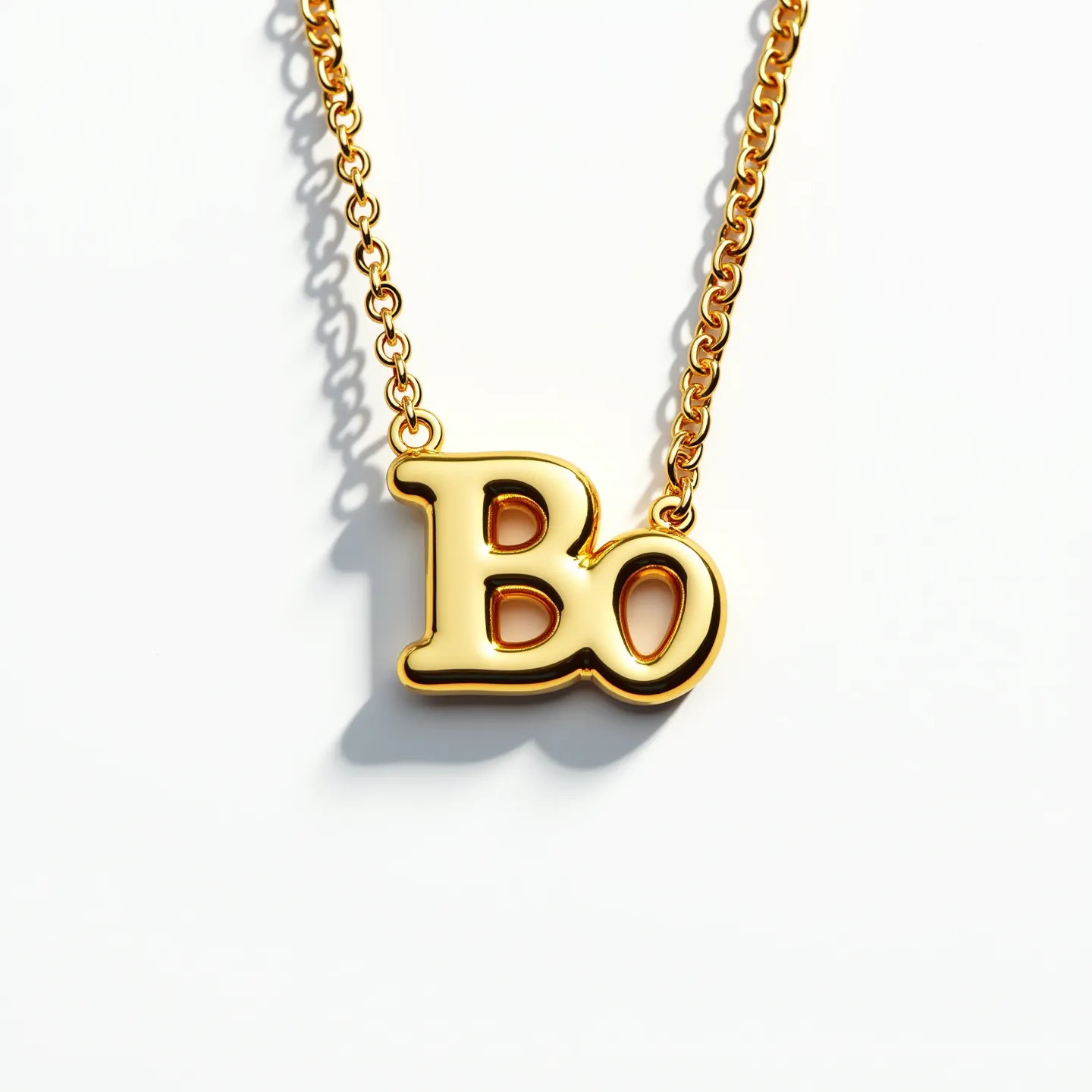 This initial necklace features a polished gold-tone metal design with the letters "Bo" as its central pendant. The letters are smoothly contoured, creating a sleek and shiny appearance, enhancing the overall elegance of the piece. The chain is composed of interconnected, evenly spaced links that complement the pendant's finish. The attachment is likely a standard closure compatible with this style of chain, ensuring secure wear. The simplicity and shine of the necklace make it a versatile accessory for various outfits.