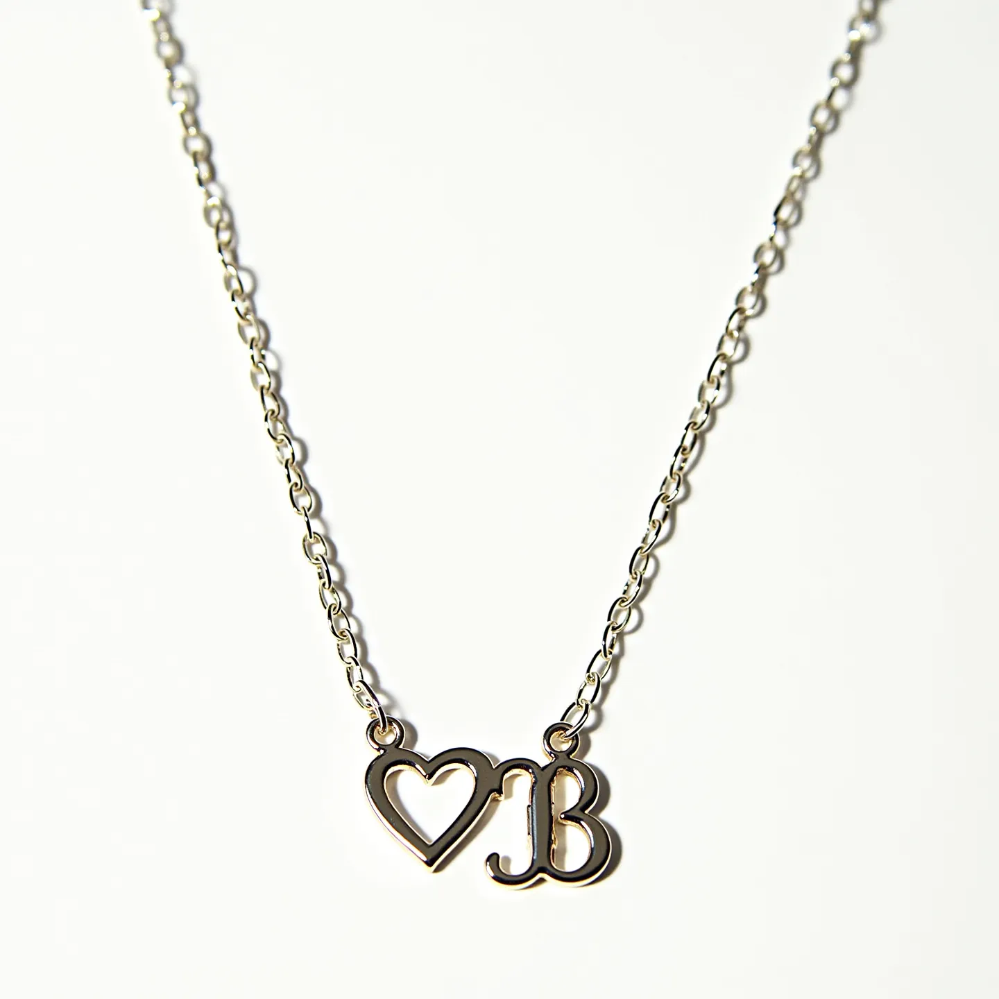 This initial necklace features a delicate chain crafted from a metallic material, possibly silver or gold, which gracefully links to two charms. The pendant includes a stylized heart shape and an initial "B," both rendered in the same metal as the chain. The charms are smoothly polished, enhancing the elegant simplicity of the piece. The chain appears to have small, evenly spaced links, contributing to its refined aesthetic. The necklace likely includes a standard clasp mechanism for fastening, though it's not visible in this view.