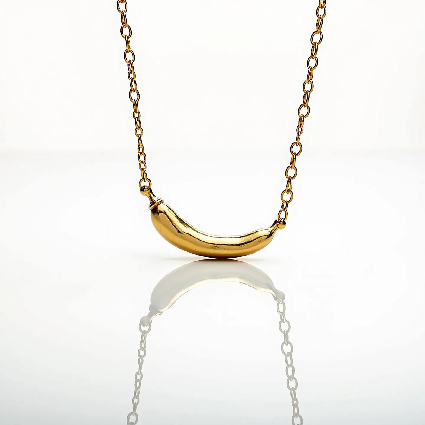 This Italian pepper necklace features a smooth, polished gold pendant shaped like a pepper, exuding a sleek and sophisticated look. The chain is composed of uniformly sized, interlocking links that complement the pendant's shiny finish. The design does not include any additional gemstones or intricate settings, maintaining a minimalist yet elegant aesthetic. The necklace appears to have a secure attachment, likely with a clasp that matches the overall gold tone, ensuring both functionality and style.