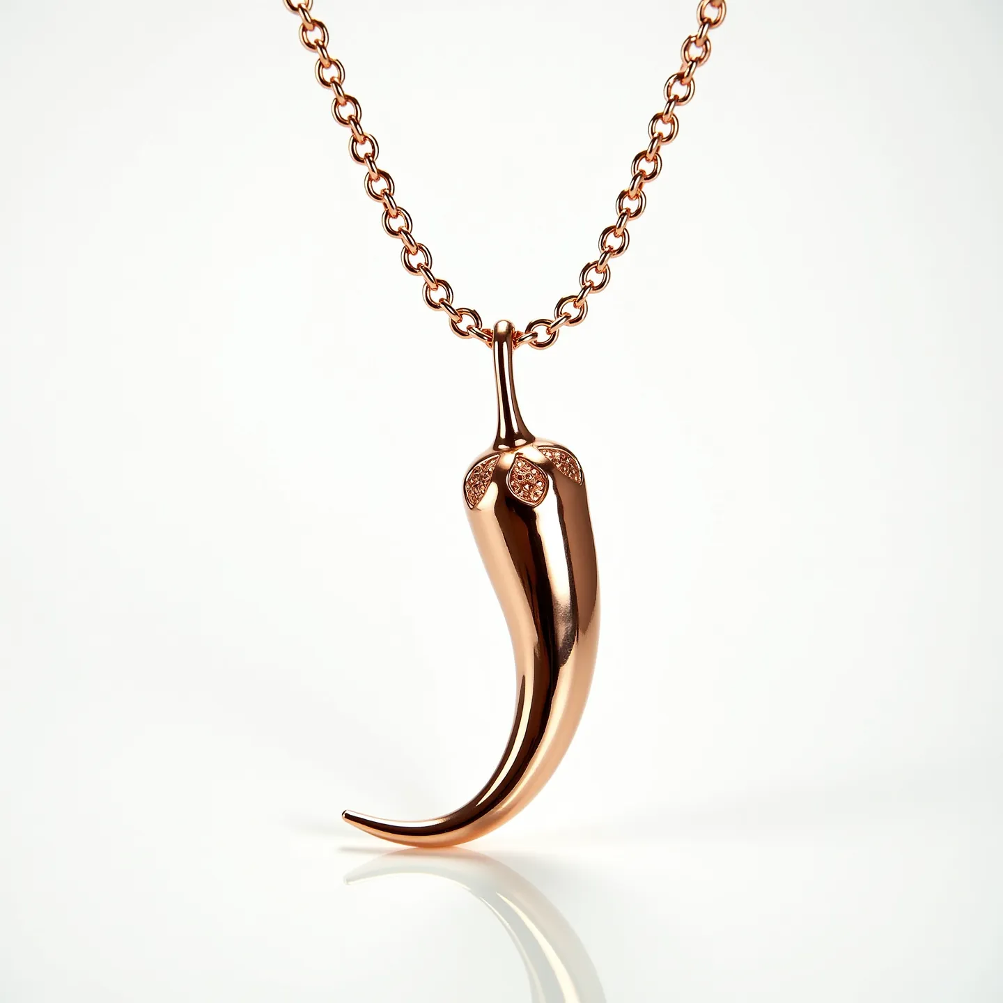 This Italian pepper necklace features a polished metal pendant shaped like a chili pepper, crafted with a lustrous rose gold finish. The pendant is adorned with small round-cut diamonds or similar stones set near the top, adding a touch of sparkle and elegance. It hangs from a sturdy, matching rose gold chain with closely linked circular loops. A simple lobster clasp completes the design for secure and easy wearing, highlighting the blend of style and functionality in this charming accessory.