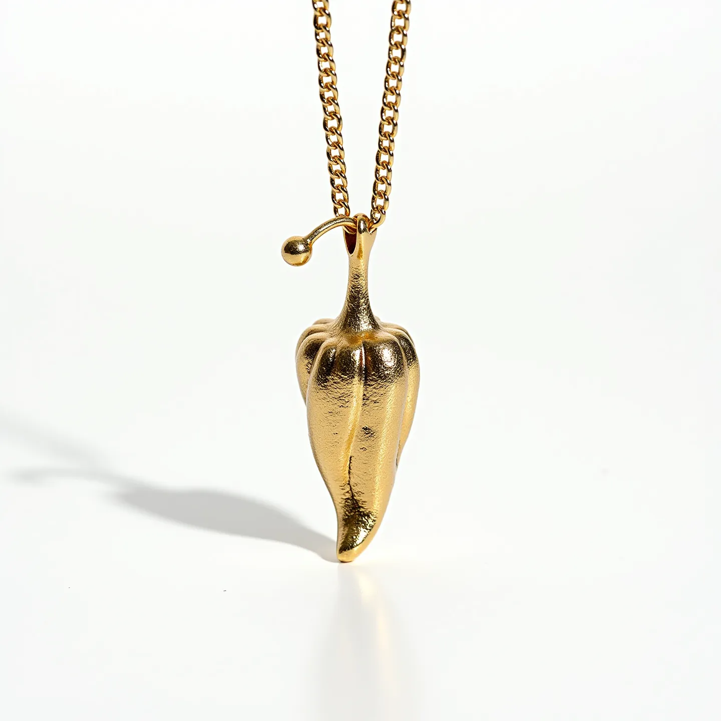 This Italian pepper necklace features a striking pendant shaped like a chili pepper, crafted from a gold-toned material that provides a luxurious and polished appearance. The pendant hangs from a chain with a similar gold finish, enhancing the overall elegance of the piece. The design does not incorporate any visible gemstones or intricate stone settings, focusing instead on the smooth, metallic surface and realistic detailing of the pepper form. The chain likely includes a simple clasp or attachment, seamlessly integrated to maintain the necklace's streamlined and cohesive aesthetic.