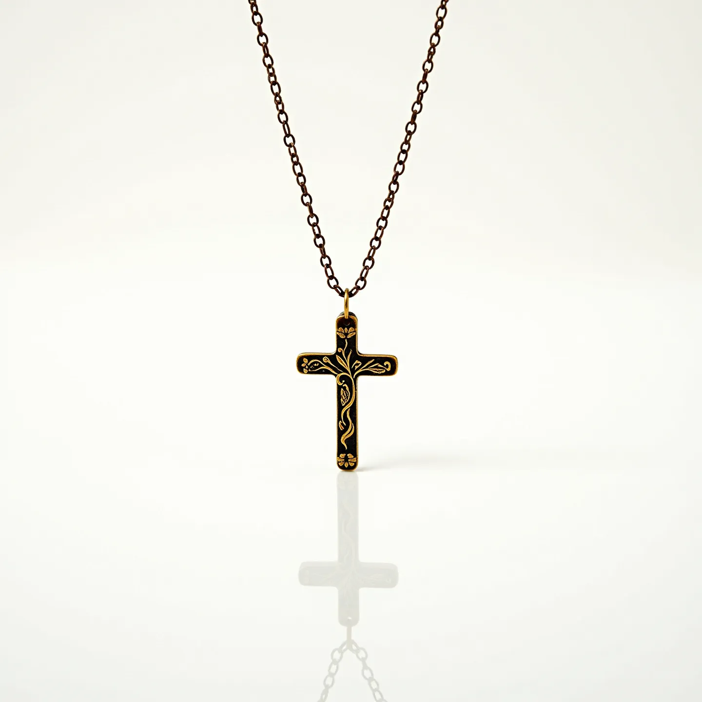 This kids cross necklace features a pendant crafted from a material that appears black, with intricate gold designs decorating its surface, lending an elegant contrast. The cross is attached to a simple, dark metal chain, which complements the pendant's design, adding to its aesthetic appeal. The necklace includes a standard loop at the top of the cross, facilitating its connection to the chain. This piece is designed with a minimalist approach, making it suitable for children and providing an element of understated elegance.