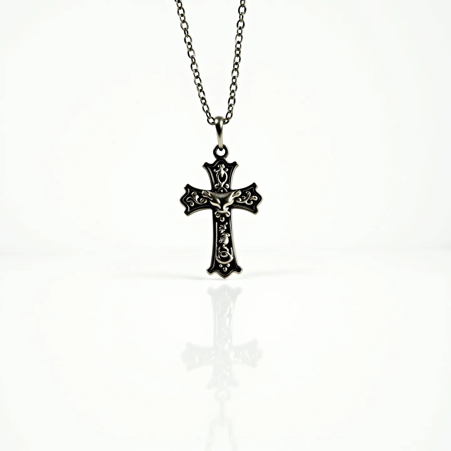 This kids cross necklace features an intricately designed cross pendant made of what appears to be a silver-toned metal. The design includes ornate patterns and a depiction of a dove in the center, adding an artistic touch to the piece. The cross is attached to a delicate chain with small, evenly spaced links, which suggests durability while maintaining a lightweight feel. The necklace is secured with a standard spring ring clasp, ensuring it stays fastened comfortably during wear. The overall craftsmanship highlights elegance and attention to detail, making it a suitable accessory for children.