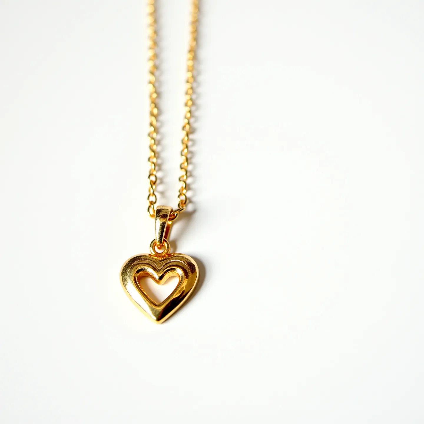 This kids gold necklace features a delicate chain made of gold links, creating a graceful and classic appearance. At its center hangs a heart-shaped pendant, also crafted from gold, showcasing a smooth and polished surface that reflects light beautifully. The pendant has an open heart design, adding a touch of charm and sophistication. The necklace likely secures with a standard clasp, ensuring it can be worn comfortably and securely. Overall, the design combines simplicity and elegance, making it suitable for a child.