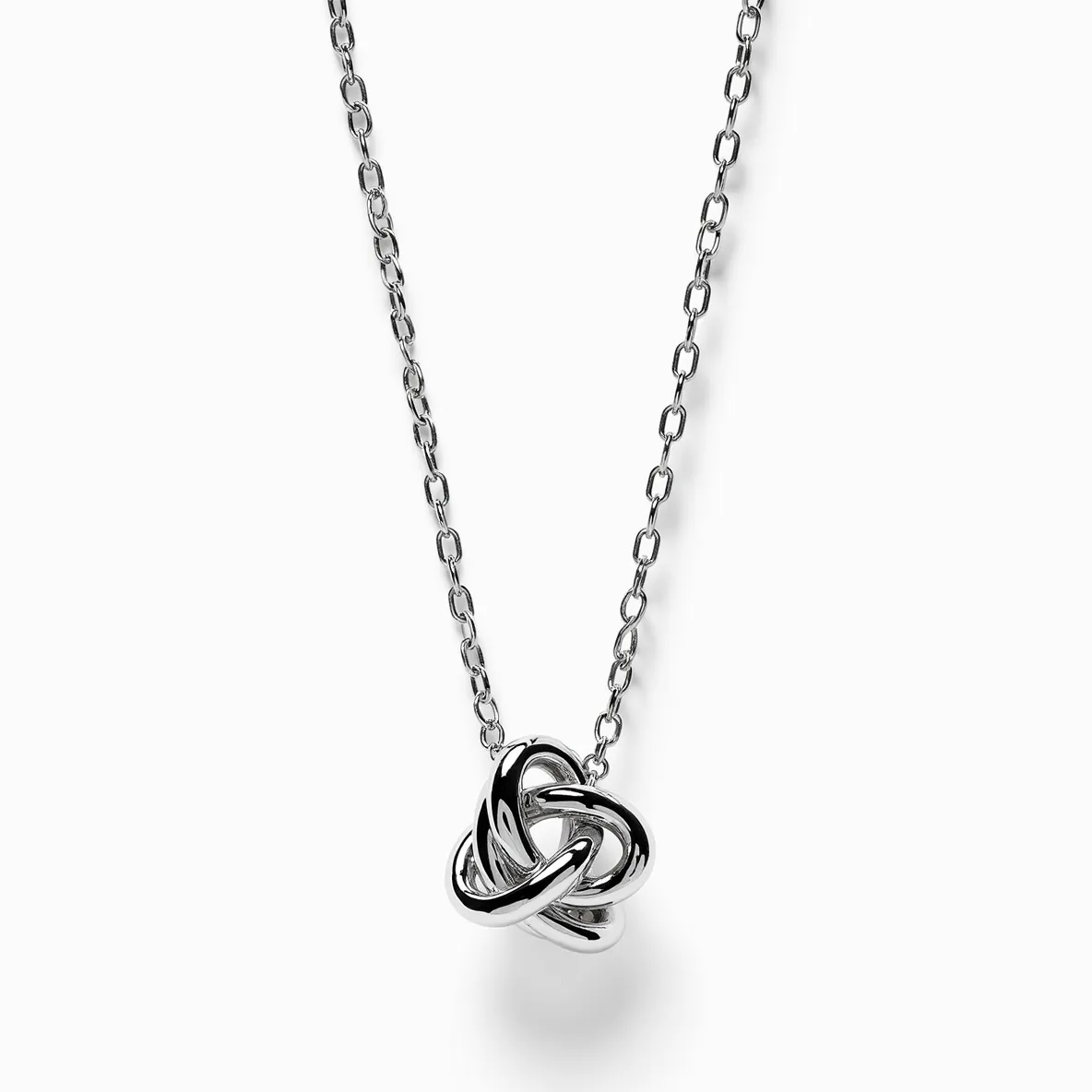 This knot necklace features a polished, intricate knot design as its central element, crafted from shiny metal, likely silver or stainless steel, which gives it a sleek and modern look. The chain consists of oval links that complement the pendant's contemporary aesthetic. This necklace lacks any gemstones, maintaining a minimalist style. It typically includes a standard clasp for secure fastening, ensuring ease of wear and removing any complexity. The overall design is both elegant and versatile, suitable for a variety of occasions.