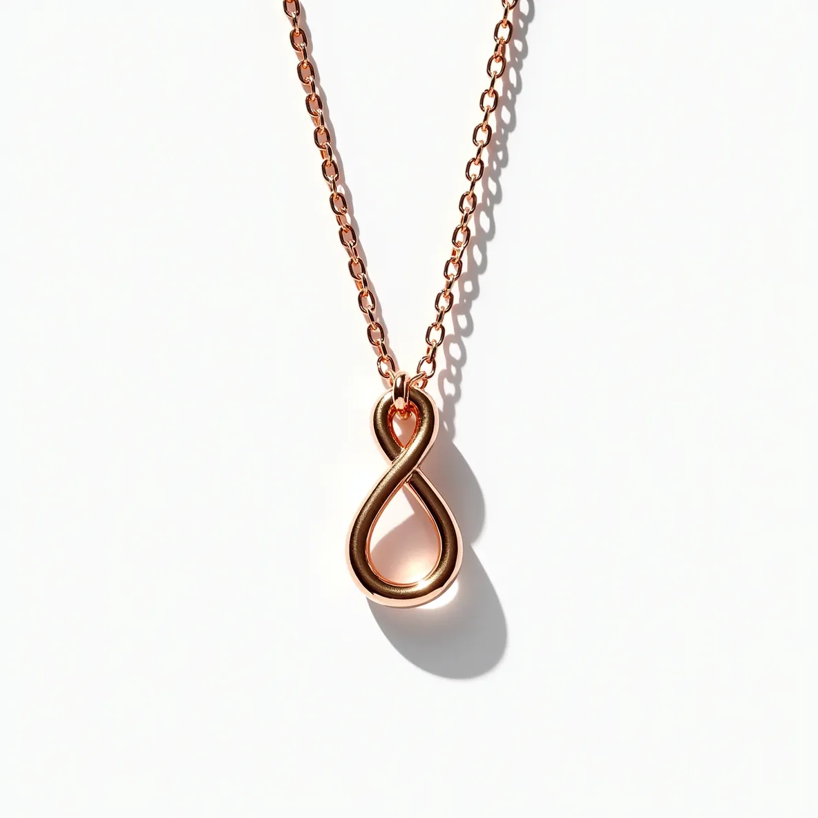 This knot necklace features a beautifully crafted infinity-style pendant made of polished rose gold, giving it a warm, lustrous appearance. The pendant hangs from a delicate rose gold chain, which complements the pendant's smooth and elegant design. The necklace does not appear to have any gemstones, focusing instead on the minimalist and sophisticated knot design. It features a simple yet secure loop clasp, ensuring the necklace stays in place while being worn. Perfect for adding a touch of elegance to everyday attire, this piece combines classic design with contemporary aesthetics.