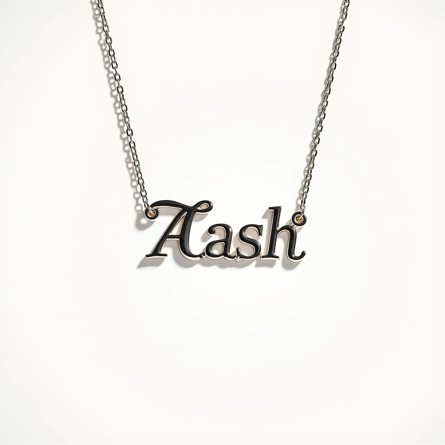 This letter necklace features the name "Aash" crafted in a sleek, reflective metal, possibly stainless steel or sterling silver, giving it a polished and modern appearance. The script is fluid and elegant, hanging from a delicate chain. The chain is likely made of the same metal as the pendant, ensuring a cohesive look. Each end of the name is securely attached with a small loop that connects to the chain, allowing the pendant to hang naturally when worn. There are no visible gems or stones embedded in the design. The necklace likely features a standard clasp, possibly a lobster or spring ring, to secure it around the neck.