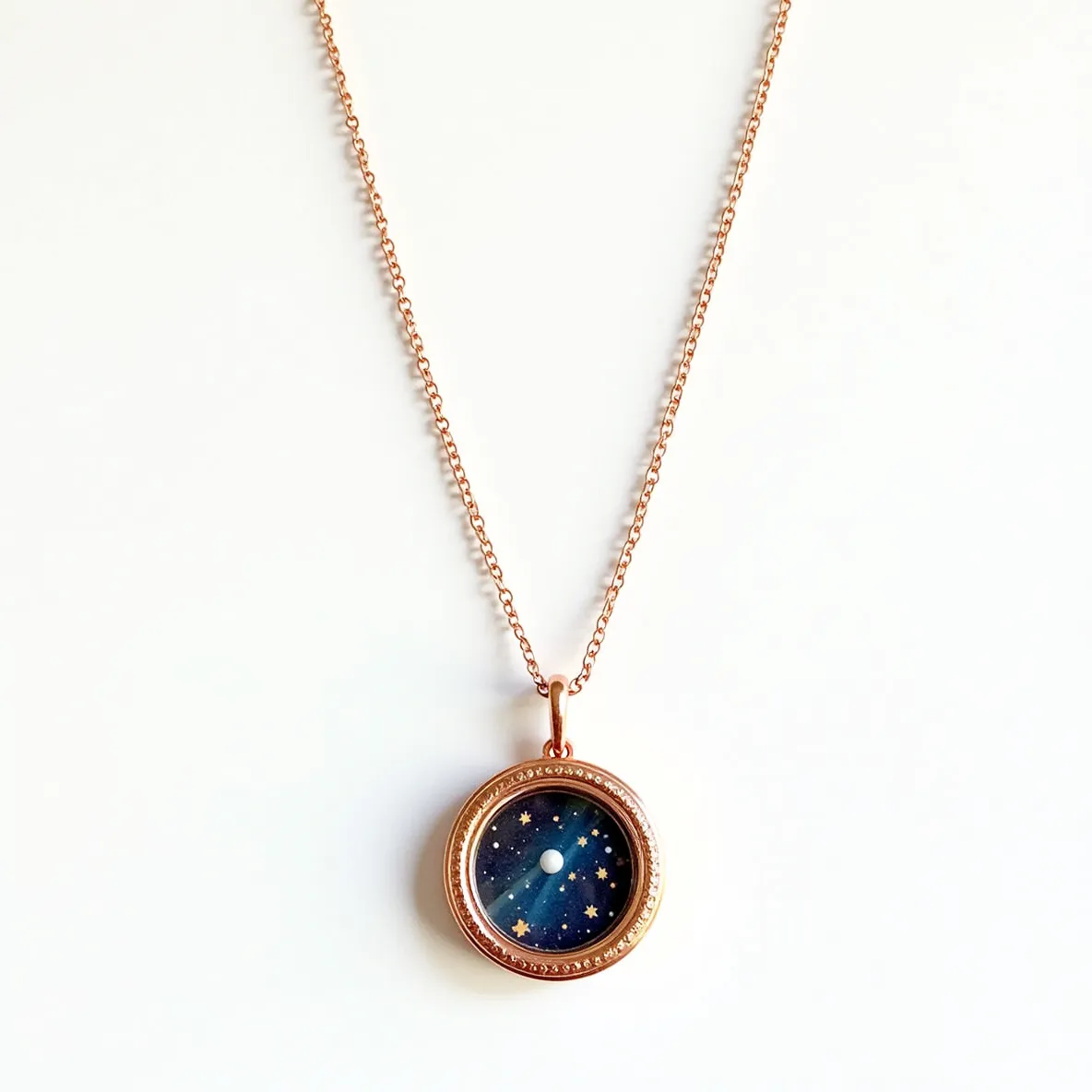 This locket necklace features a delicate rose gold chain that elegantly supports a circular pendant. The locket itself is crafted with a rose gold bezel, surrounding an artistic depiction of a starry night sky. The centerpiece of the design is a circular white gem, resembling a miniature moon amidst the stars. The setting is smooth, enhancing the celestial theme without additional embellishments, and it is securely fastened to the chain with a simple rose gold loop clasp. The refined design and cohesive color palette create a harmonious and tasteful accessory.