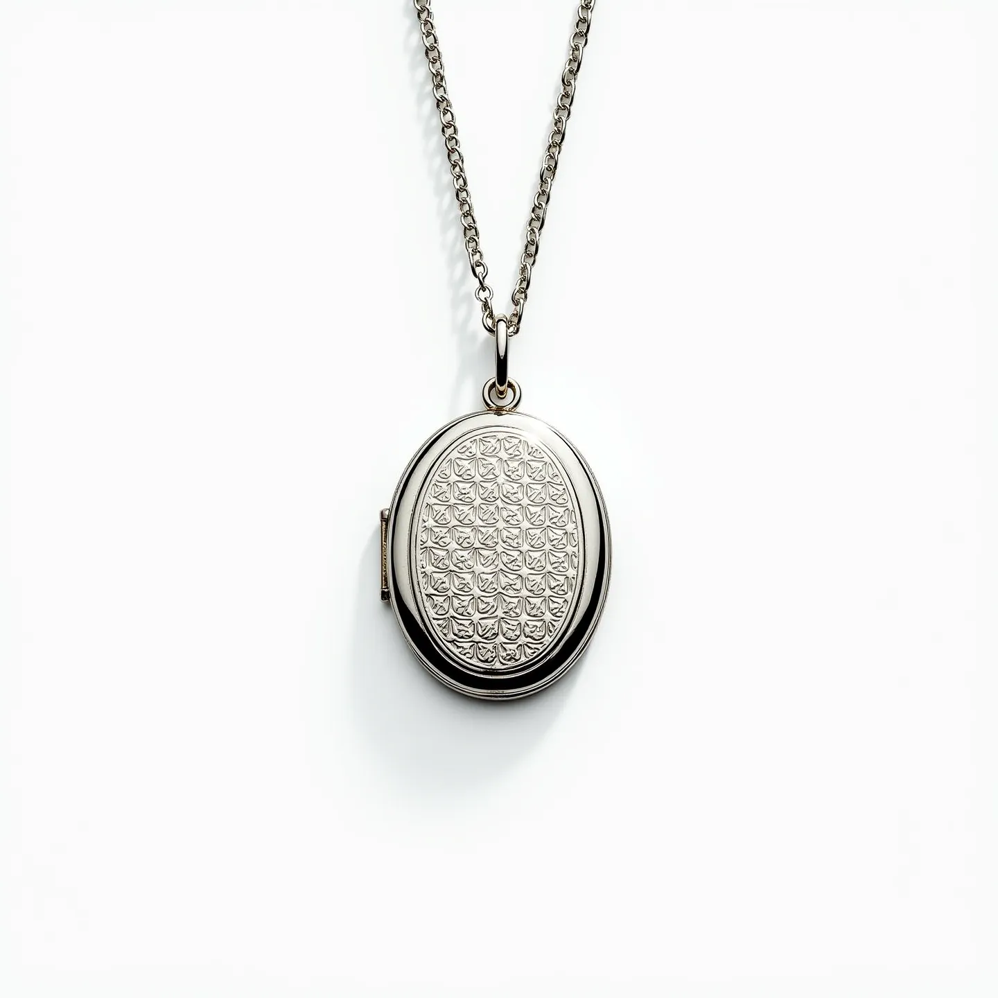 This locket necklace features an oval-shaped pendant crafted from polished metal with intricate, repeating patterns engraved on its surface, creating a textured design. The locket is suspended from a delicate cable chain, which is likely made of the same metal, providing a cohesive look. The chain is fastened with a classic spring ring clasp, ensuring secure wear. The locket design allows for sentimental storage, though no internal details are visible. This piece combines elegance and timeless style, suitable for various occasions.