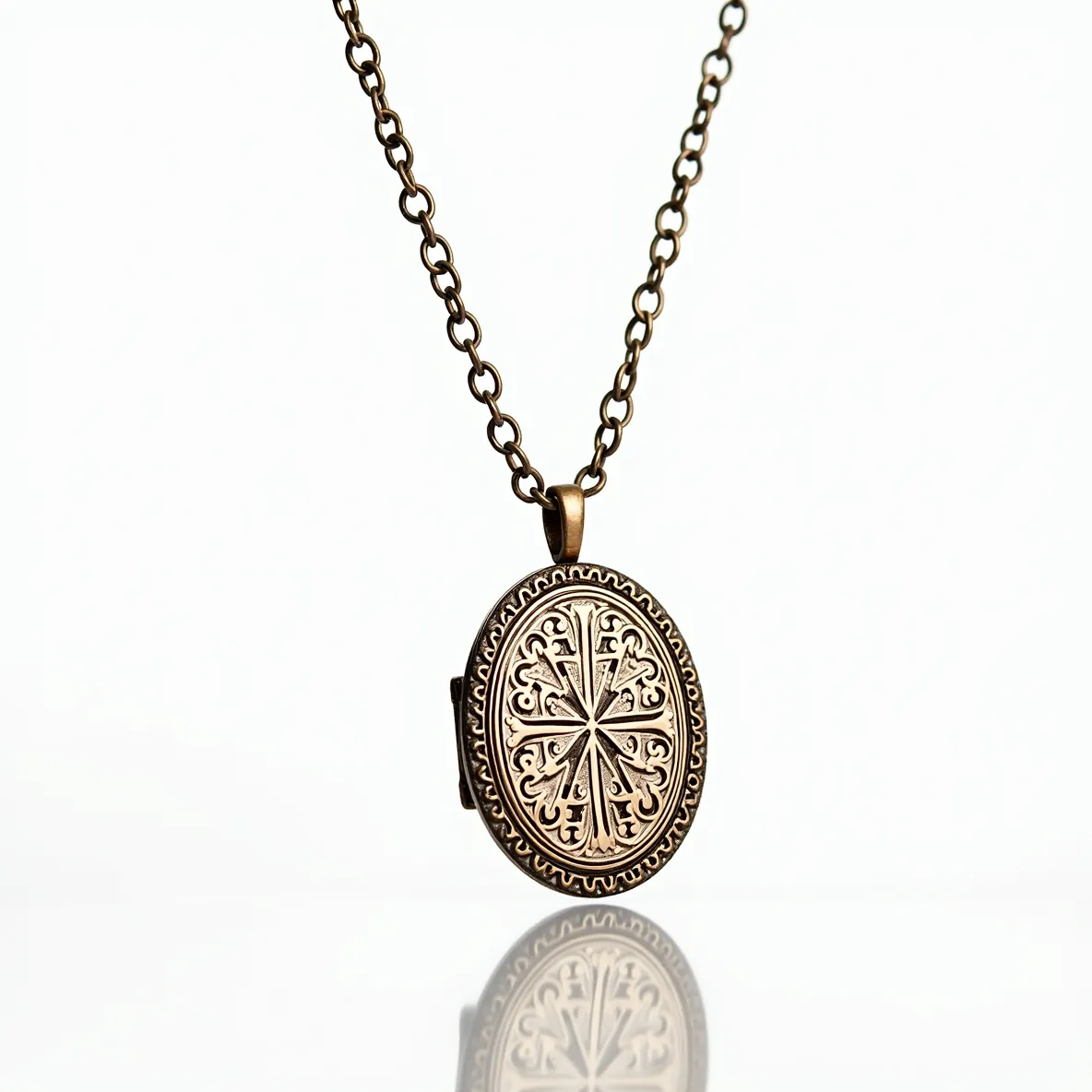 This locket necklace features a vintage-style brass oval pendant adorned with an intricate engraved design, showcasing a symmetrical motif that resembles traditional patterns. The locket hangs from a matching brass chain with medium-sized links, providing a balanced and classic look. The pendant is attached to the chain with a simple bail that complements the overall antique aesthetic. The necklace closes with an easy-to-use lobster clasp, ensuring both security and convenience.